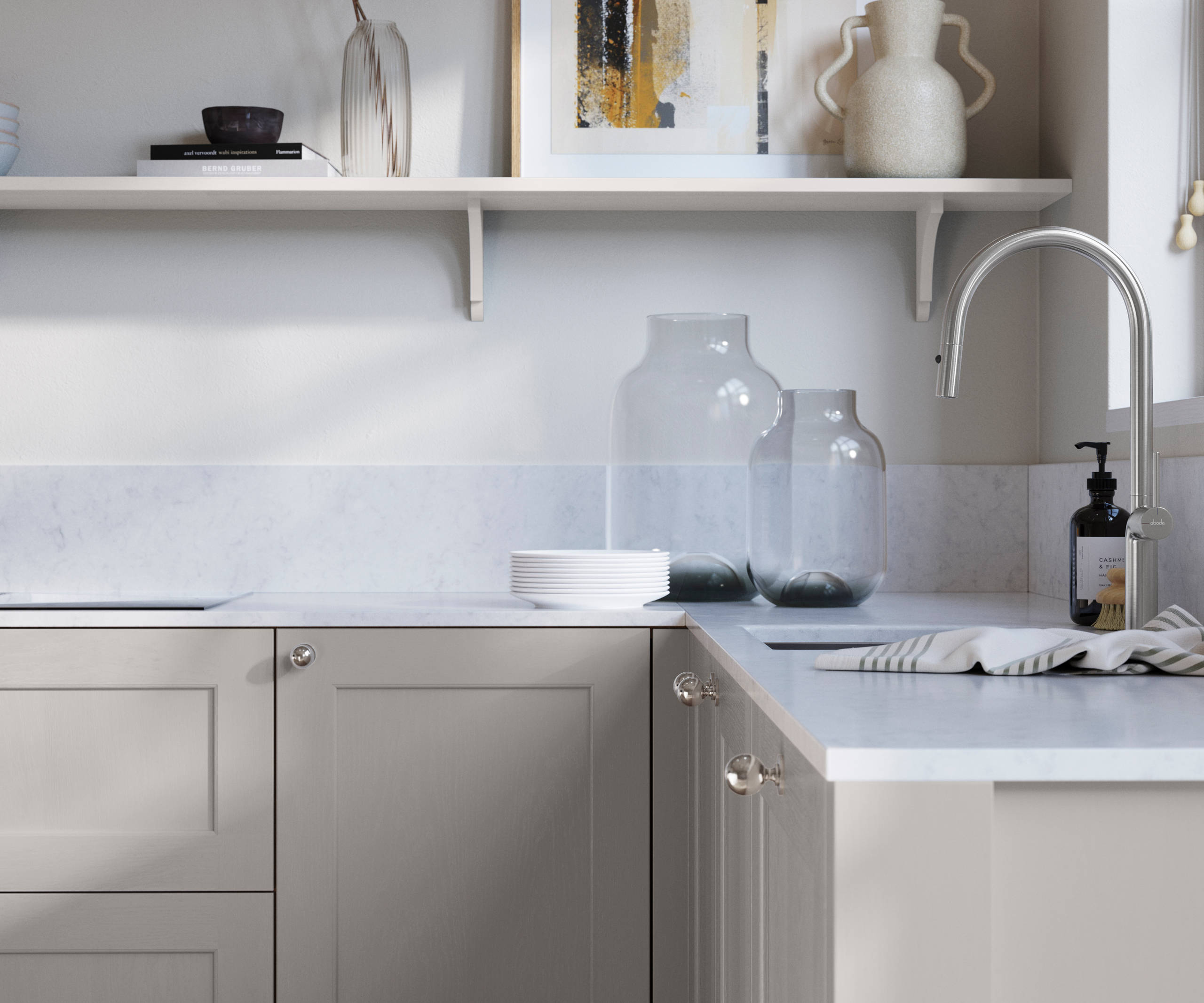 Ludlow, a traditional Shaker-style premium feel kitchen range with a visible woodgrain on its panelled doors here shown in the light grey shade Dove grey styled with steel knobs, steel tap, a white marbled worktop with matching splashback.