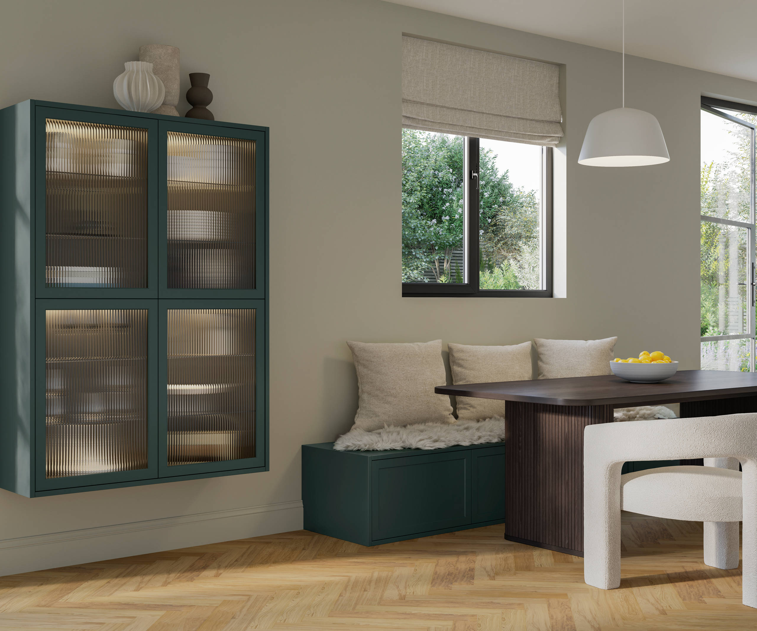 Seating area in muted green modern shaker Brunswick kitchen, a green bench with woft white pillows and wall cabinetry with fluted glass fronts.