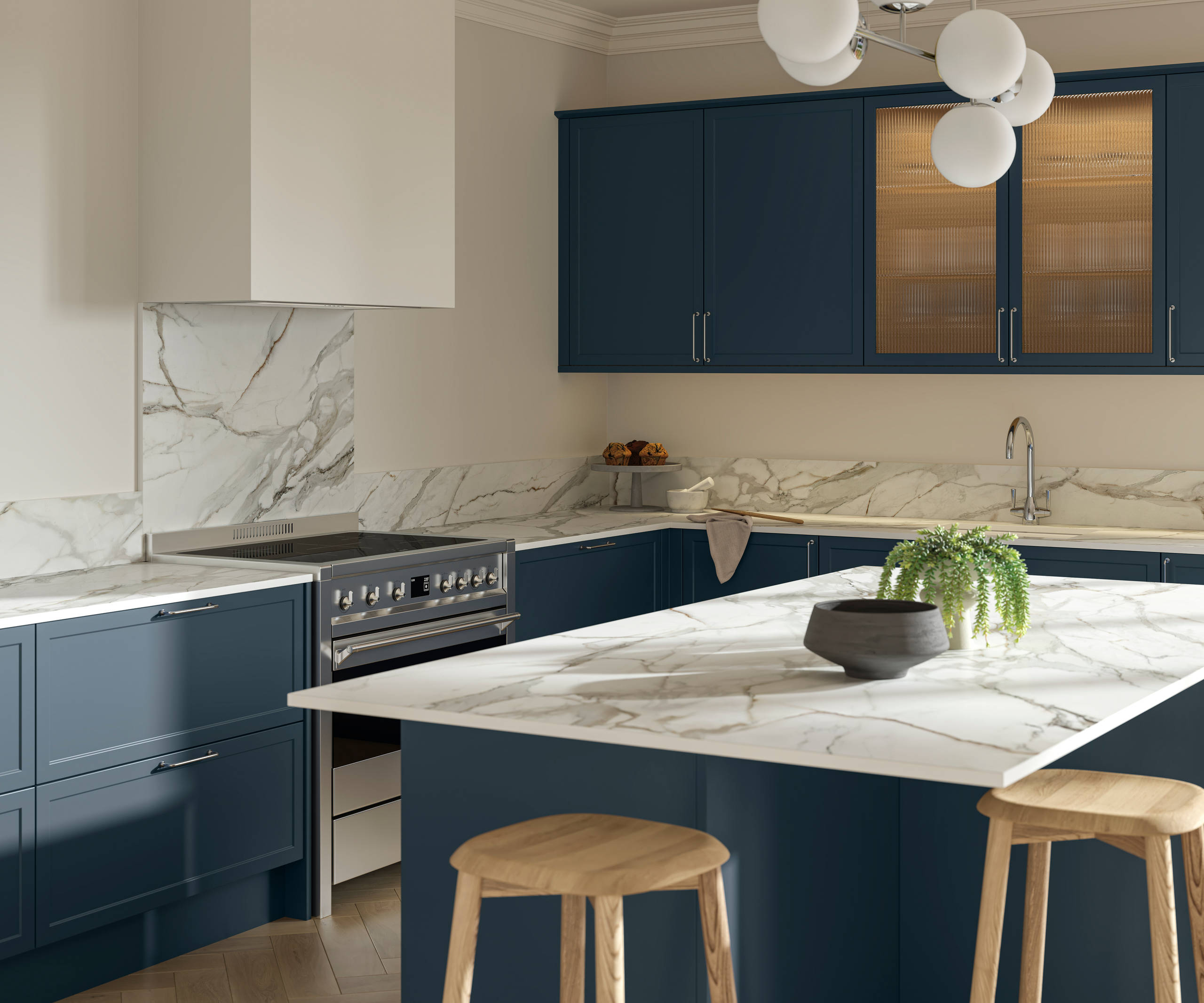 View over kitchen island breakfast bar in modern Shaker kitchen Brunswick Voyage blue with white and grey marbled worktop and matching splashback, and vitrine cabinets with fluted glass.