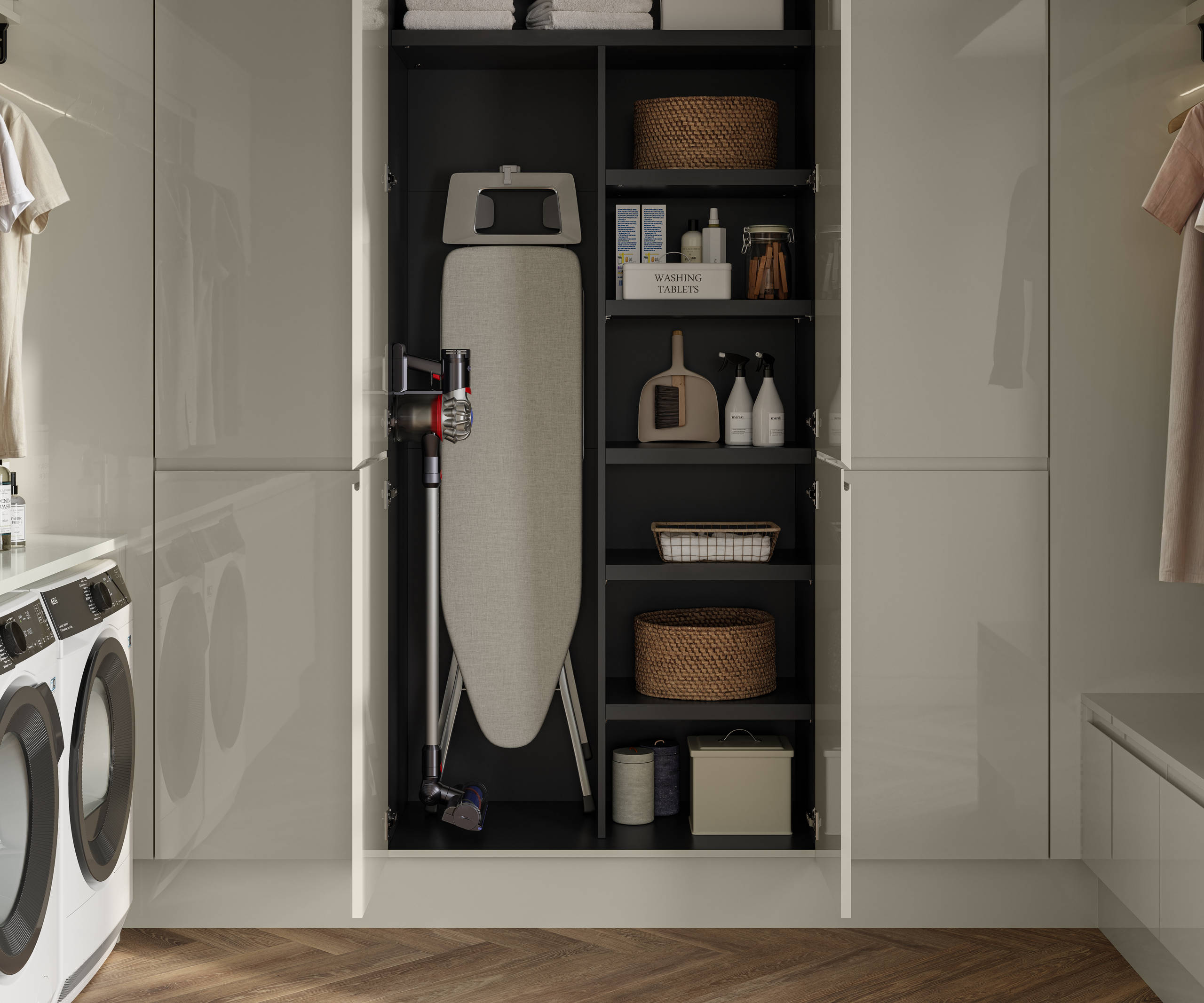Luna Gloss Limestone utility room with tall cabinets, opened cabinets showing storage of Ironing board and laundry detergents, Amtico smouldered oak in parquet flooring.