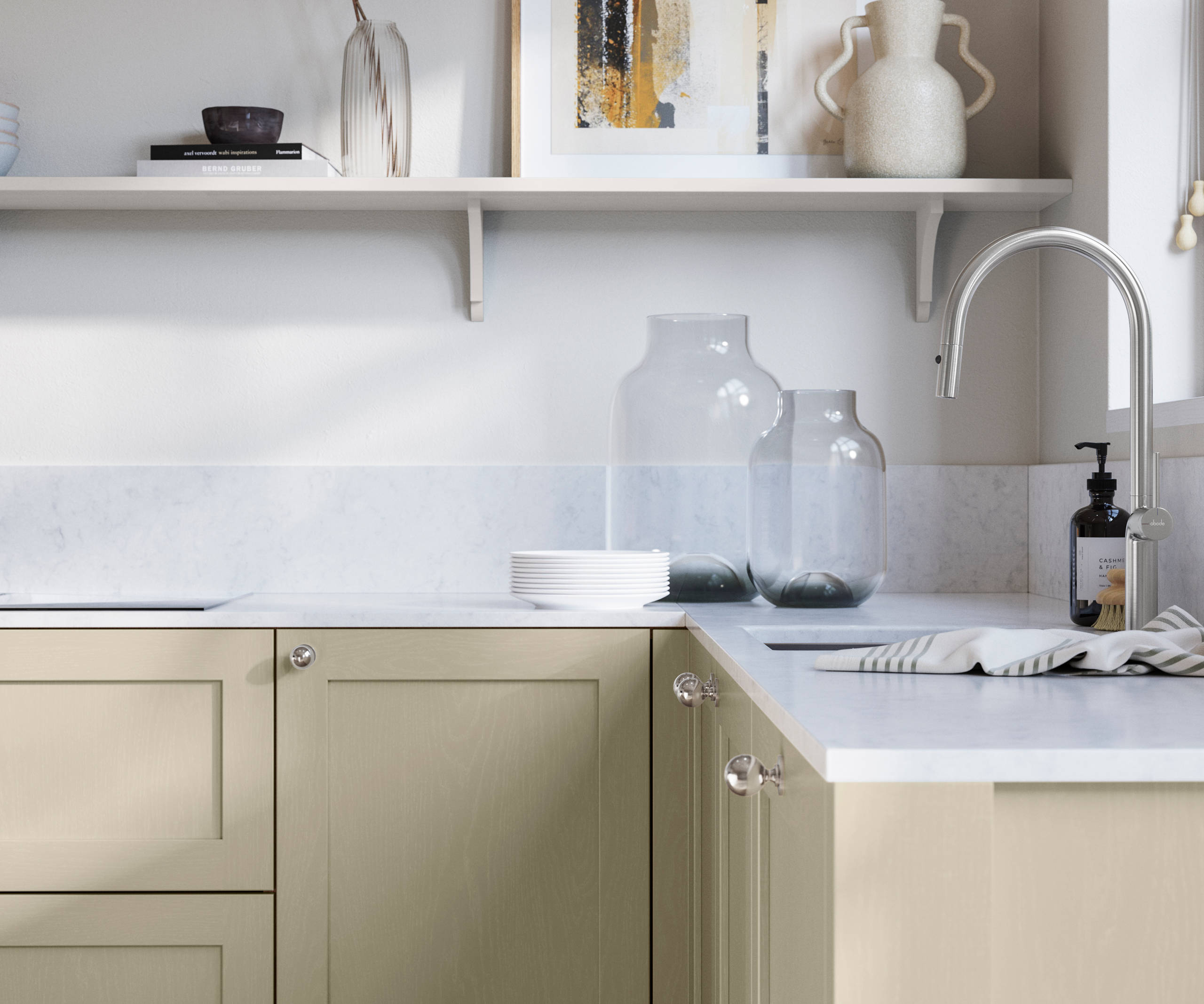 Wardley Parchment kitchen cabinetry with steel knobs, steel tap, white marbled worktop and matching backsplash. An open shelf on the wall above cabinets with ceramics and a vase of flowers.