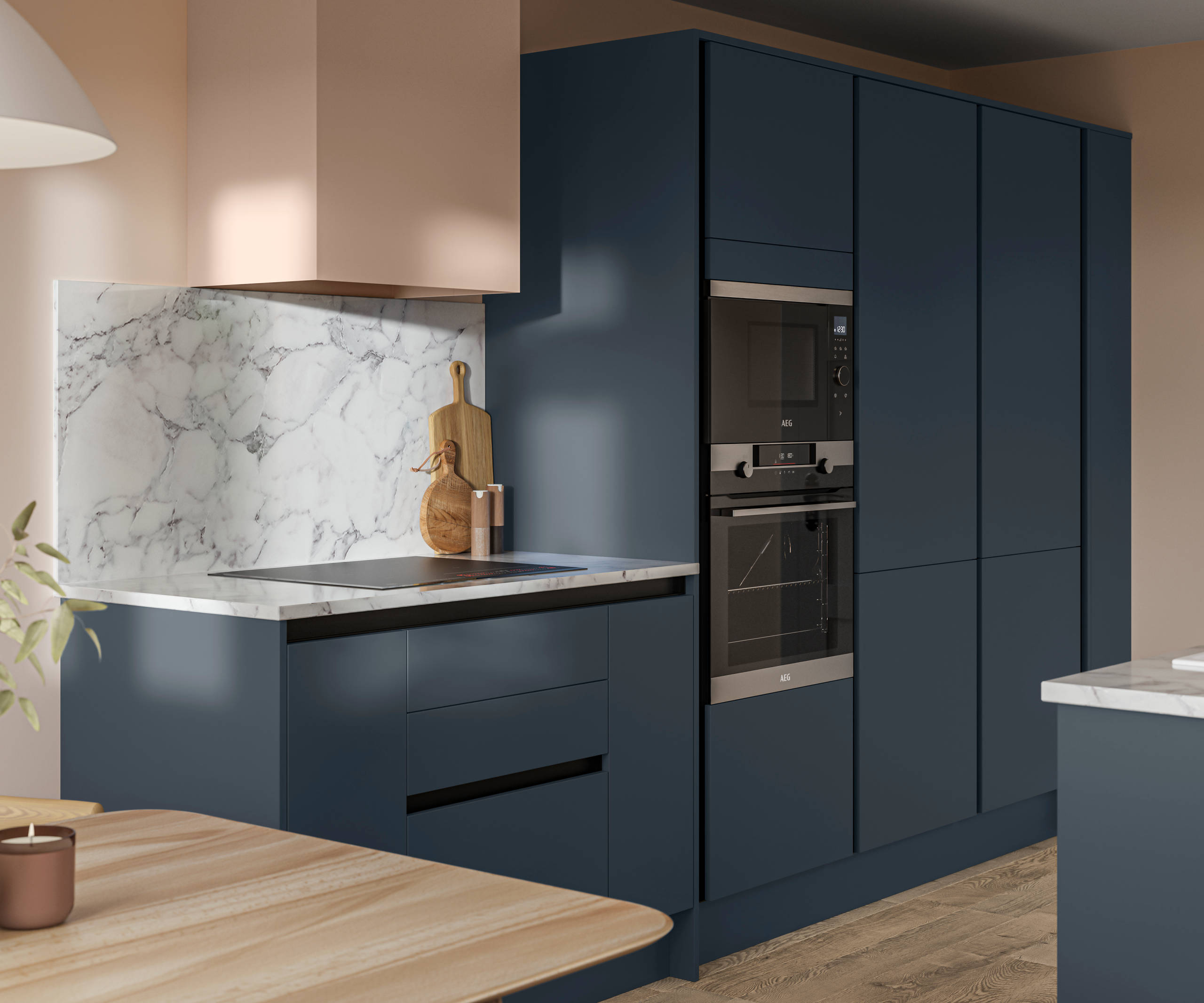 Handleless Integra Ascoli Mineral Blue, a dark blue kitchen with built-in ovens in tall cabinetry, an induction hob in white and grey marbled worktop with matching backsplash.