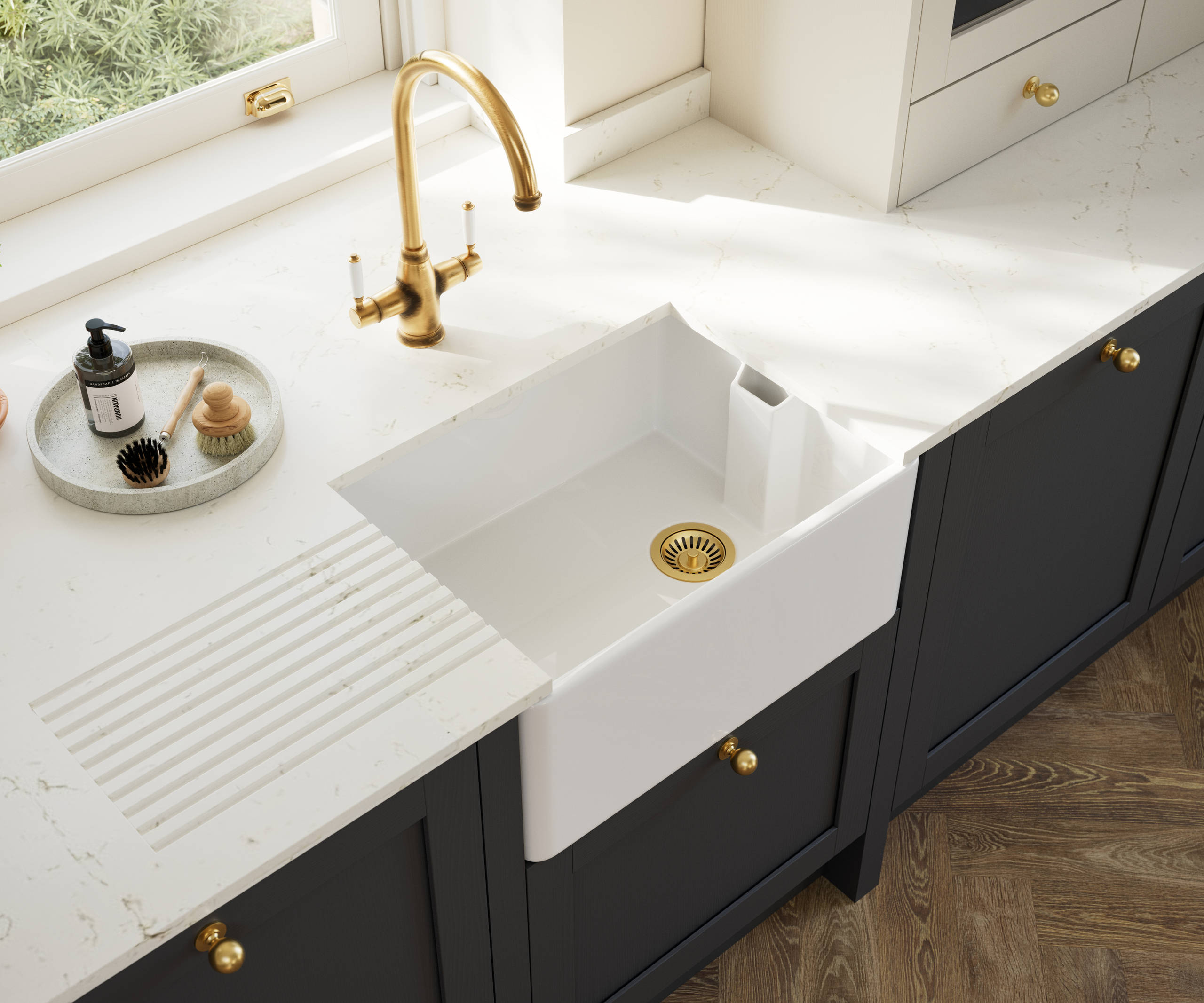 Overhead view of veramic belfast sink and brass tap in Contemporary Shaker kitchen Ambleside from Magnet in deep blue shade Lake with beige tall cabinets