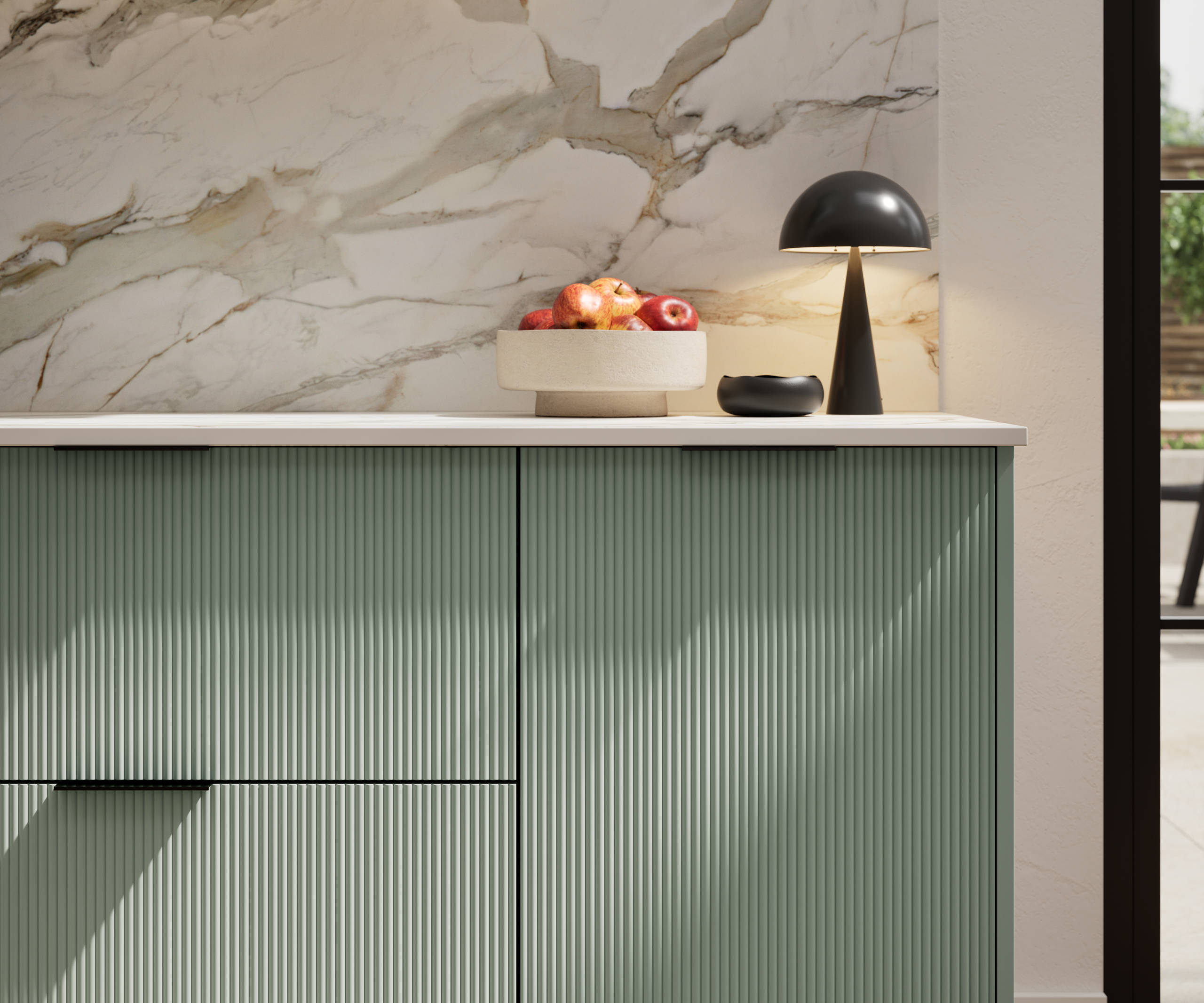 Fluted front kitchen Reed from Magnet in light green shade Eucalyptus Green, with a marbled splashback and black handles, herringbone wood flooring.
