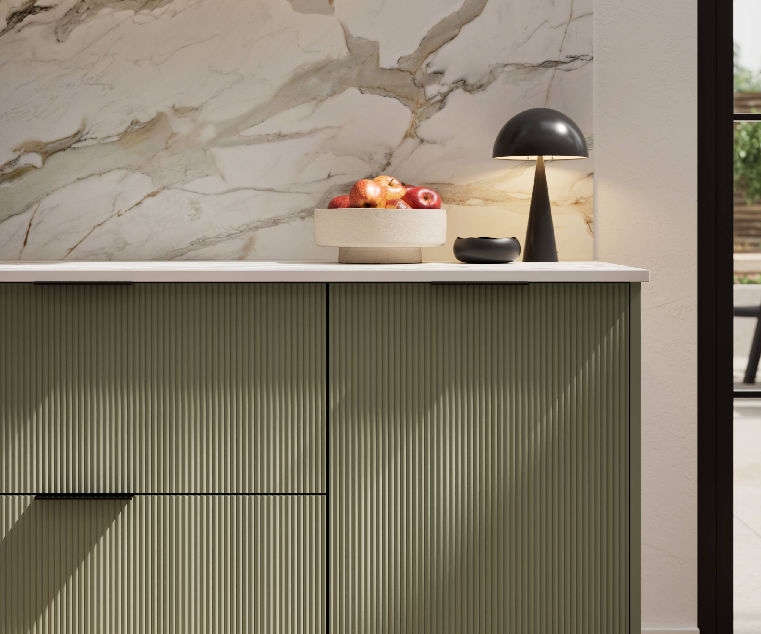 Fluted front kitchen Reed from Magnet in green shade Misty Moors, with a marbled splashback and black handles, herringbone wood flooring.