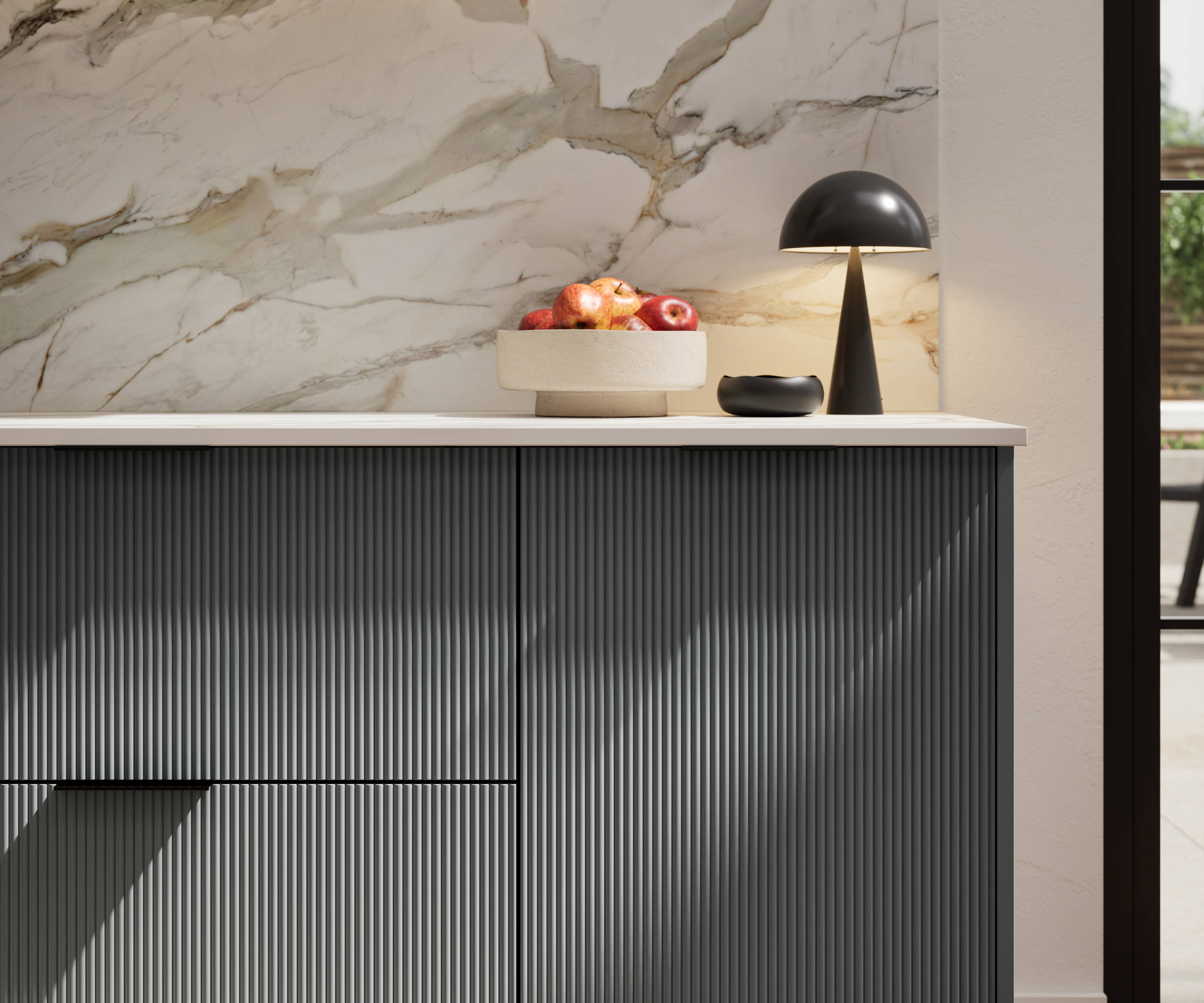 Fluted front kitchen Reed from Magnet in dark green shade Arboretum, with a marbled splashback and black handles, herringbone wood flooring.