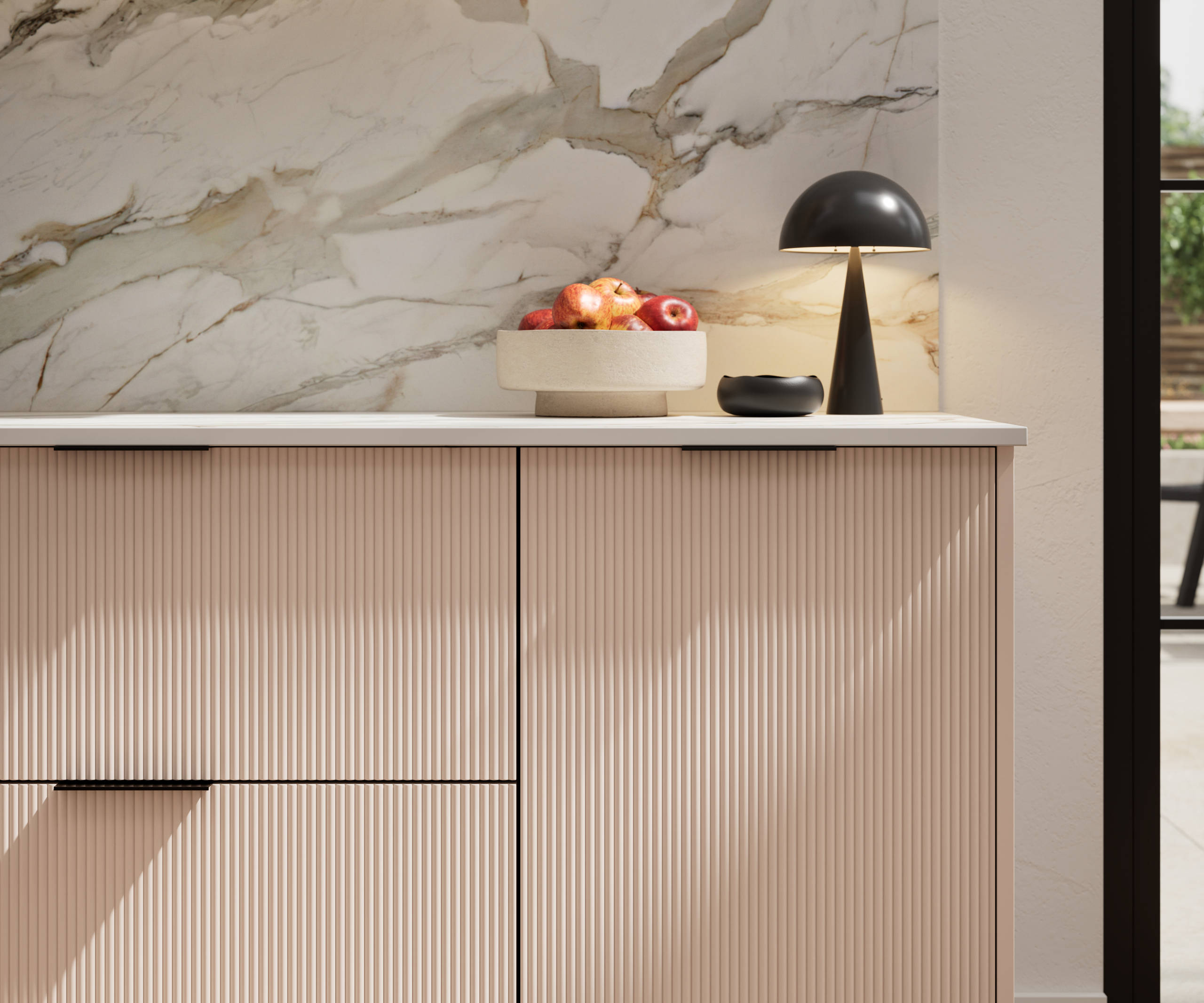 Fluted front kitchen Reed from Magnet in light neutral pink shade Chalk Blush, with a marbled splashback and black handles, herringbone wood flooring.