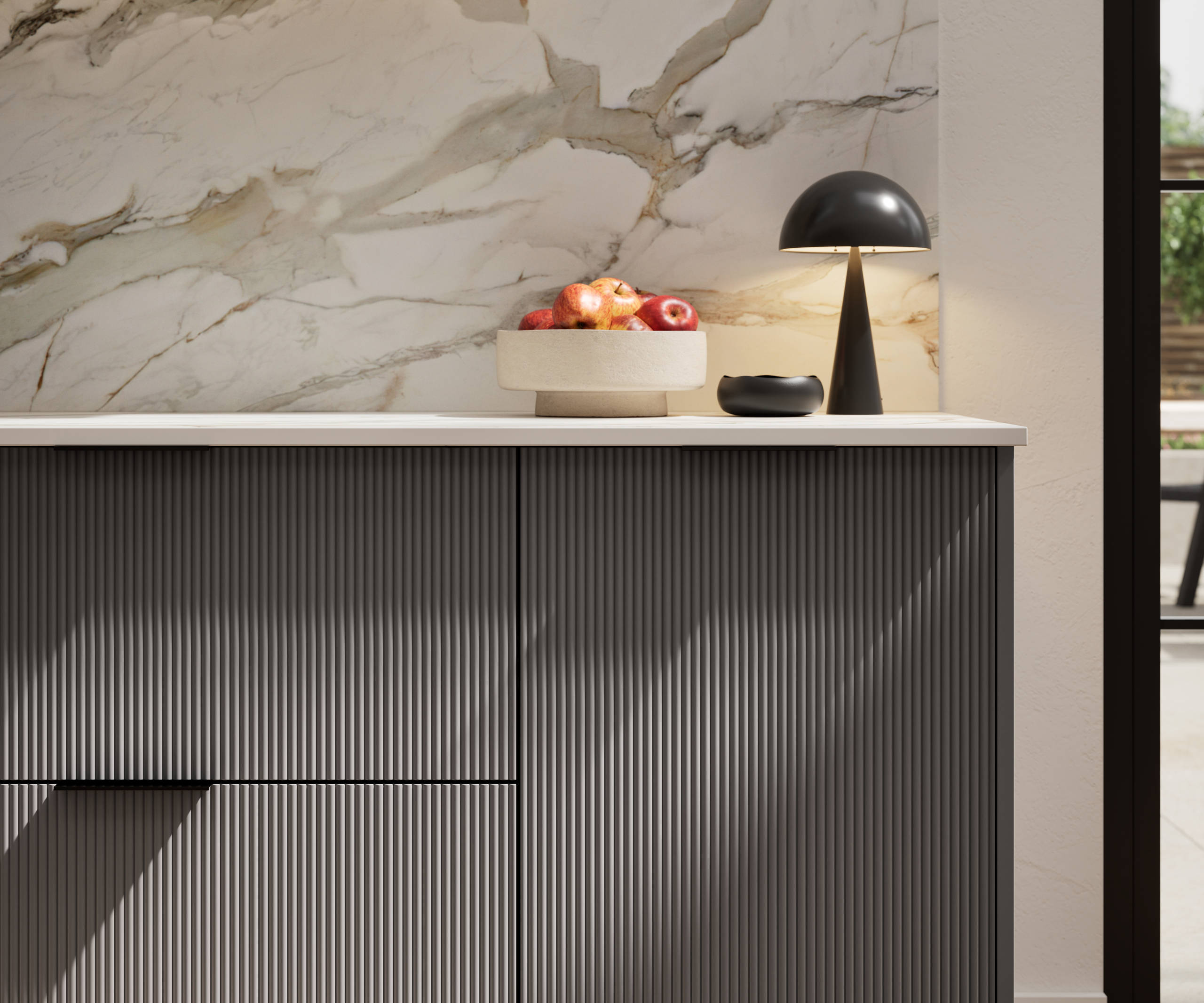 Fluted front kitchen Reed from Magnet in dark grey shade Charcoals, with a marbled splashback and black handles, herringbone wood flooring.