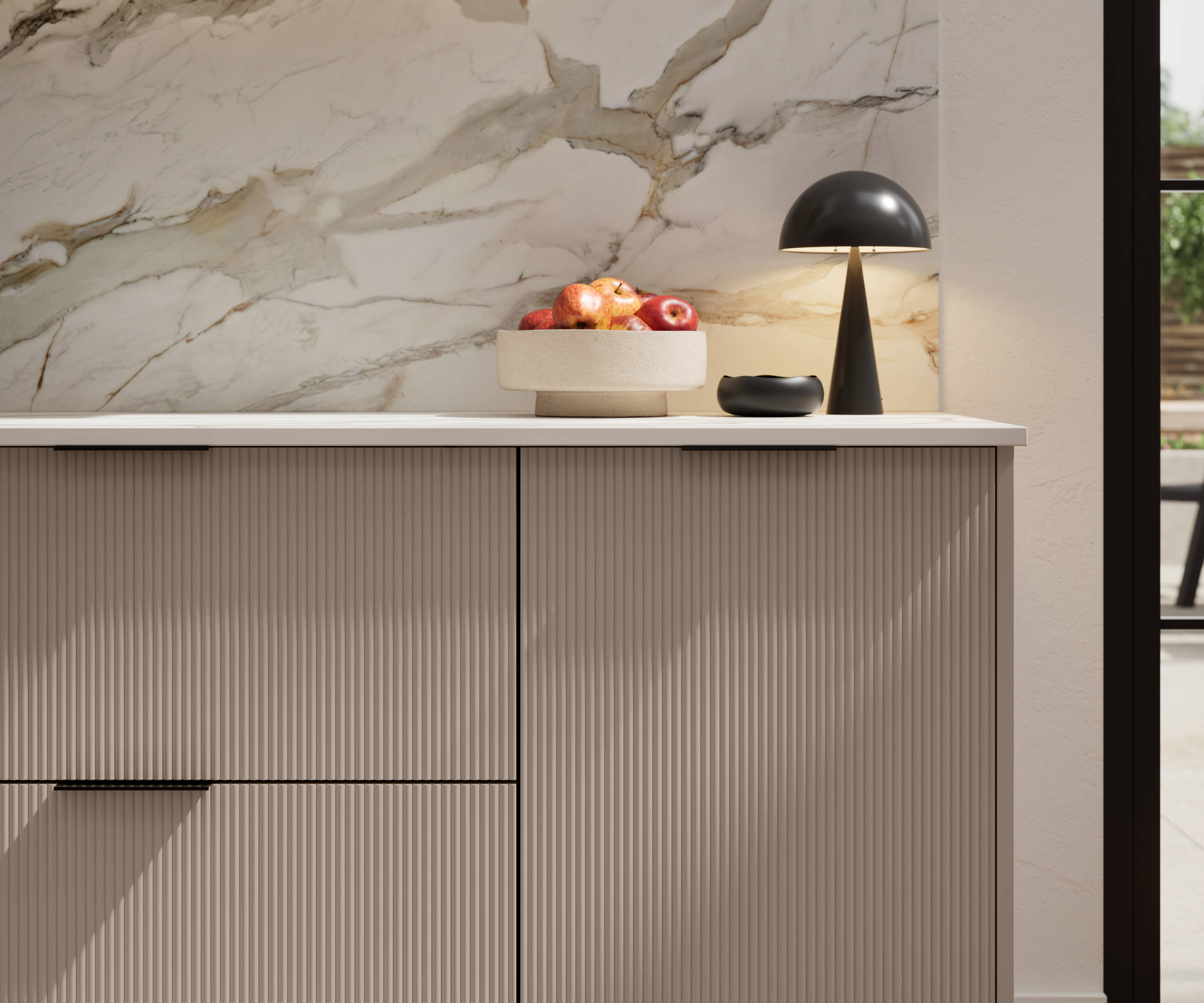 Fluted front kitchen Reed from Magnet in neutral shade Cornish Clay, with a marbled splashback and black handles, herringbone wood flooring.