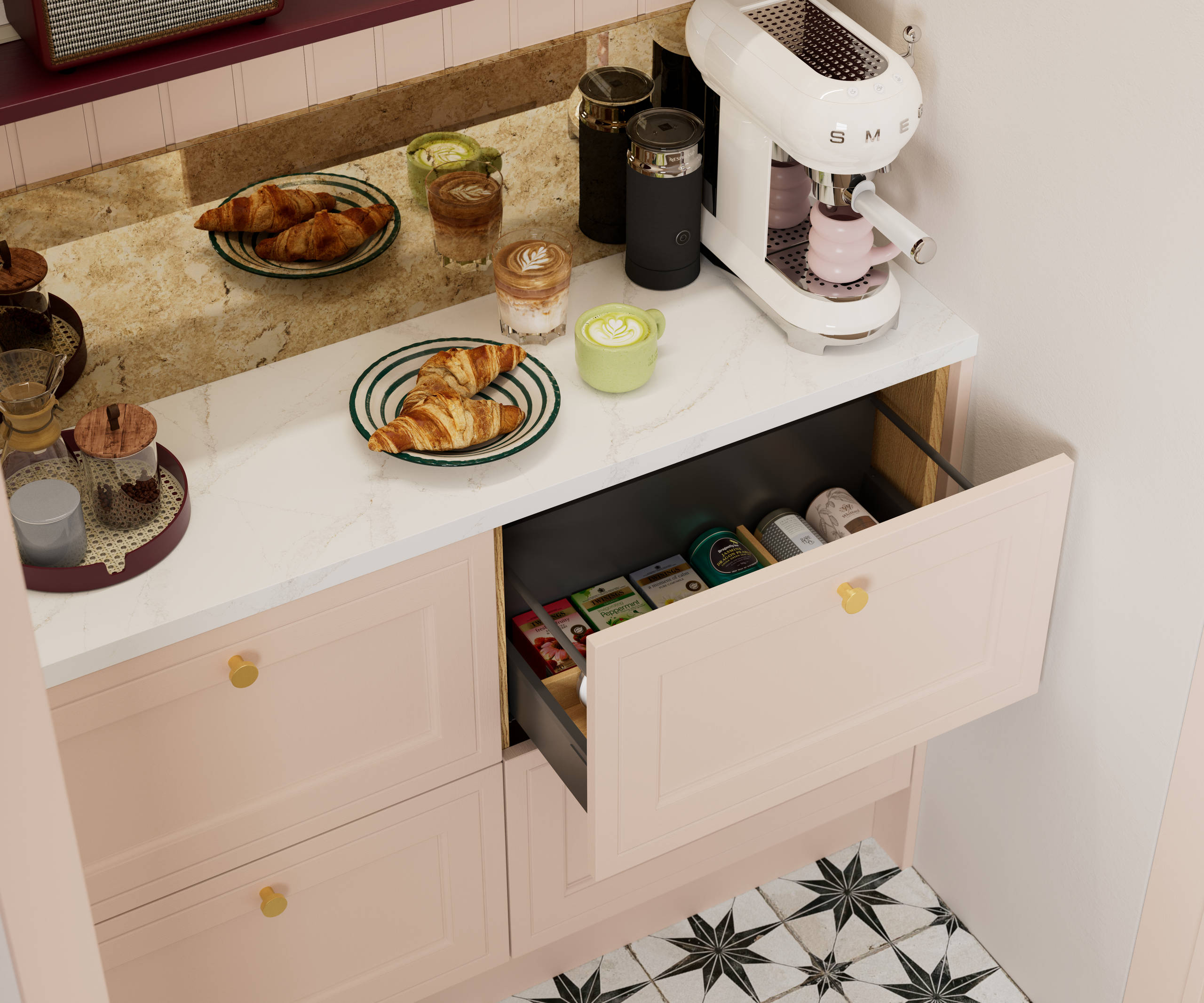 Opened drawer of teas in painted wood grain Shaker style Bewdley cabinets in light pink shade Chalk Blush, with marbled worktop, brass knobs and Smeg coffee machine on countertop.