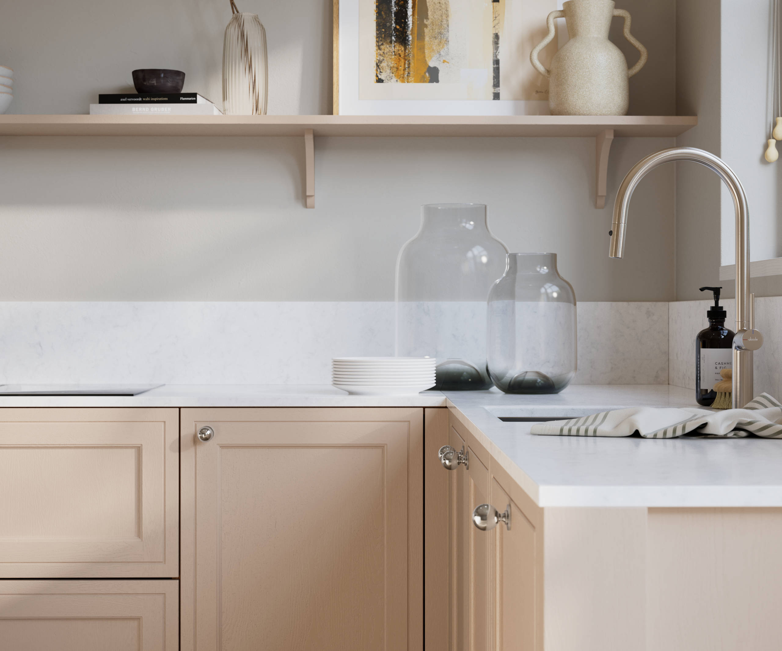 Bewdley Chalk Blush painted wood grain Shaker kitchen cabinetry with steel knobs, steel tap, white marbled worktop and matching backsplash, an open shelf on the wall above cabinets with ceramics and a vase of flowers.
