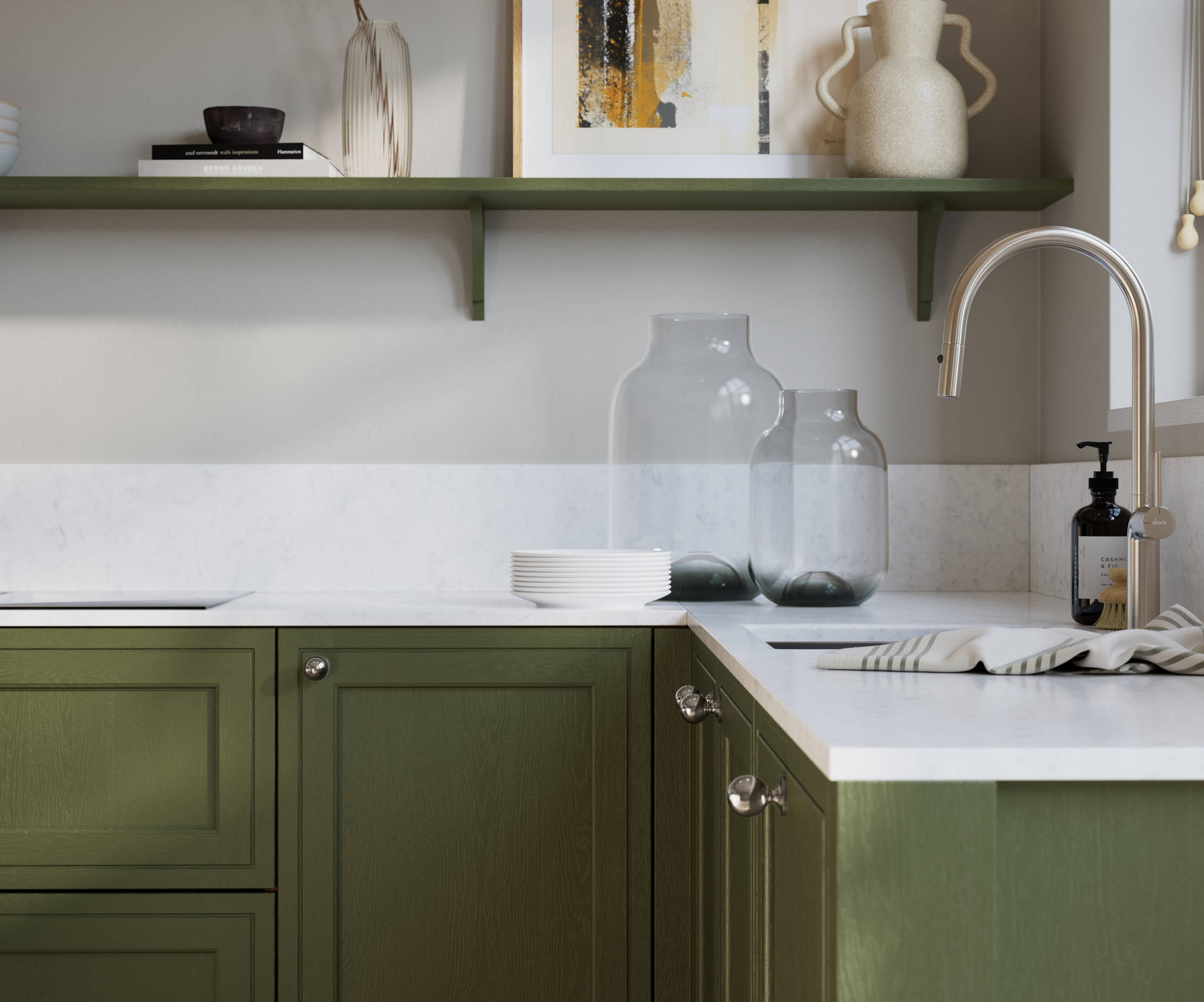 Bewdley Tailored Green painted wood grain Shaker kitchen cabinetry with steel knobs, steel tap, white marbled worktop and matching backsplash, an open shelf on the wall above cabinets with ceramics and a vase of flowers.