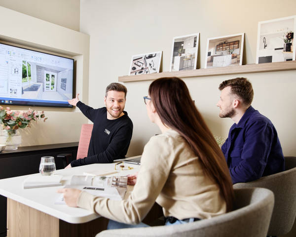 Magnet kitchen designer consulting customers in a Magnet store, showing a kitchen design.
