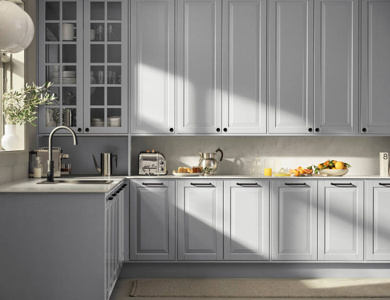 Lys grå landkøkken Nordic Sky fra INVITA med fyldningslåger, sort håndtag, vitrineskab med sprosselåger og hvid marmor laminatbordplade