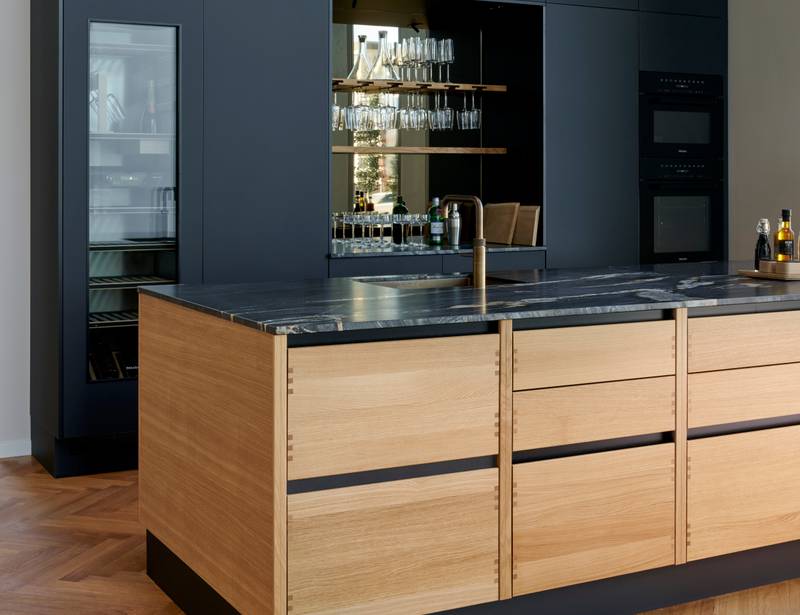 Køkkenøya Glød fra INVITA , skuffer i massivt egetræ med fingertappede samlinger og sort granit bordplade