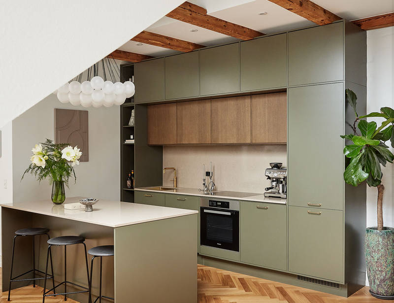 Grønt køkken med træskabe og køkkenø