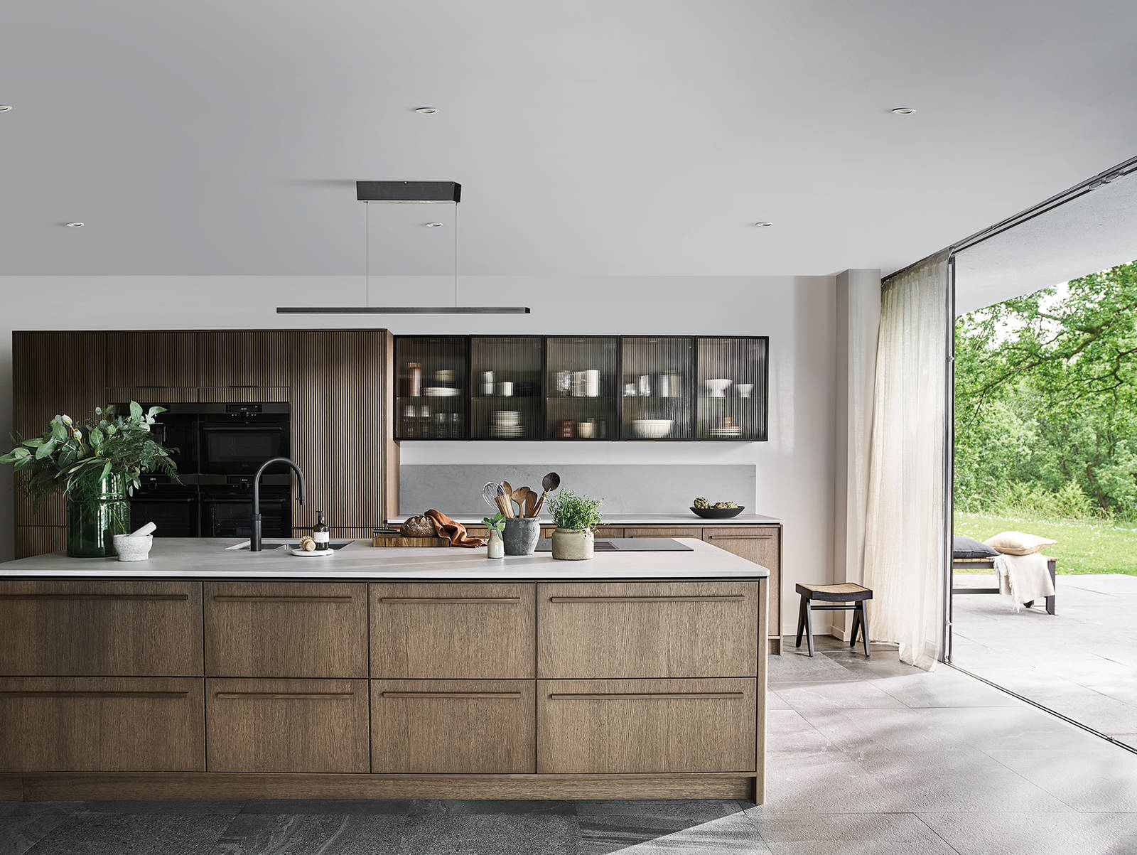 Magnet Kitchens 2021 Nordic Nature range with Fluted oak cabinets with Dekton Aeri worktop. Floating island with boiling hot water tap.