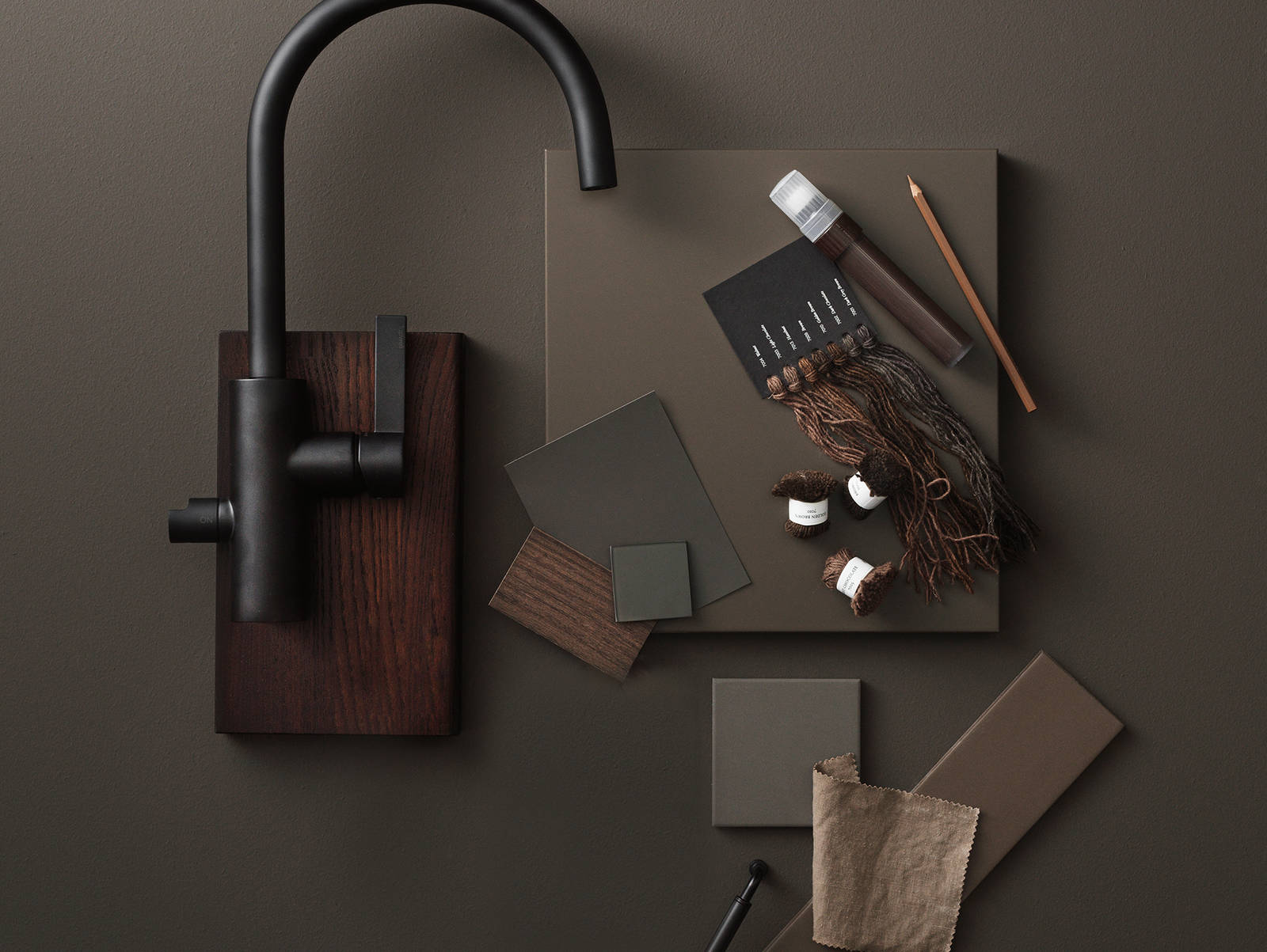 Slät brun kökslucka, slät kökslucka i brunbetsad ek, svart rundad blandare från tapwell, färgprover i naturmaterial