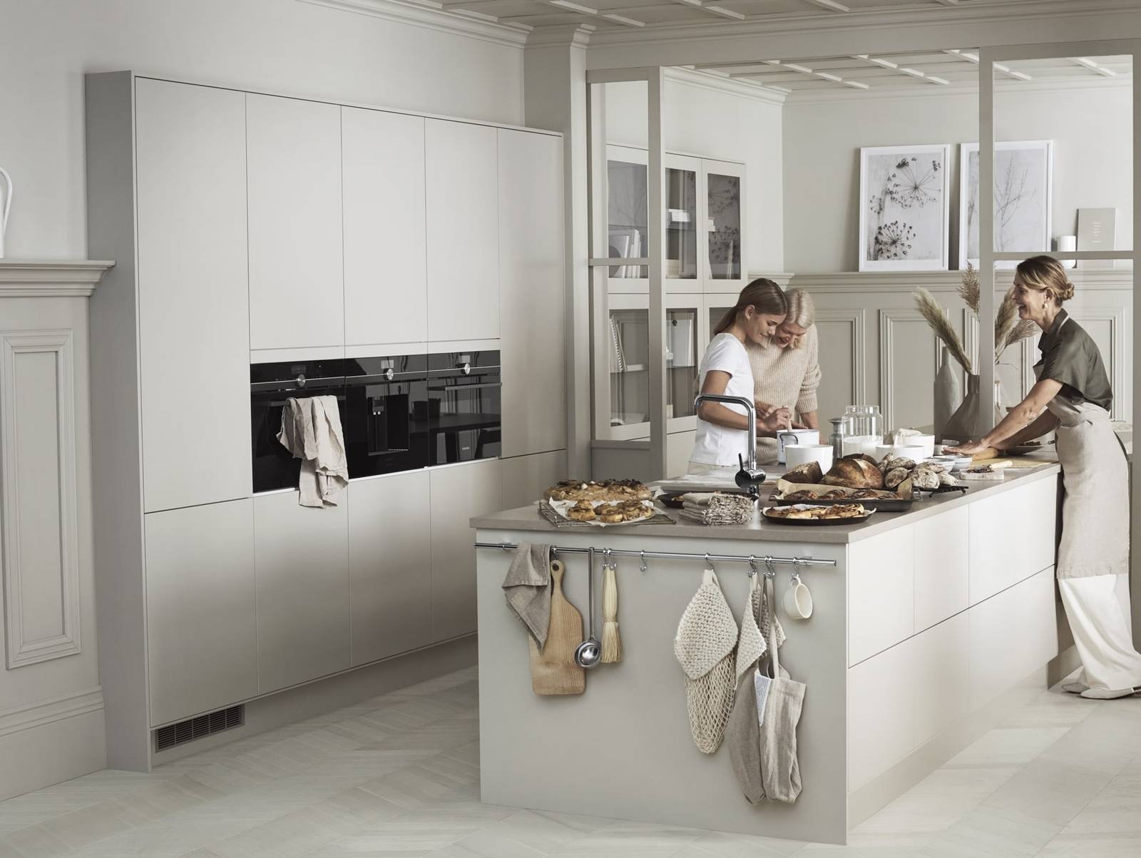 En familiebakst i det moderne beige Line kjøkkenet fra Sigdal med glatte dører i fargen Korn