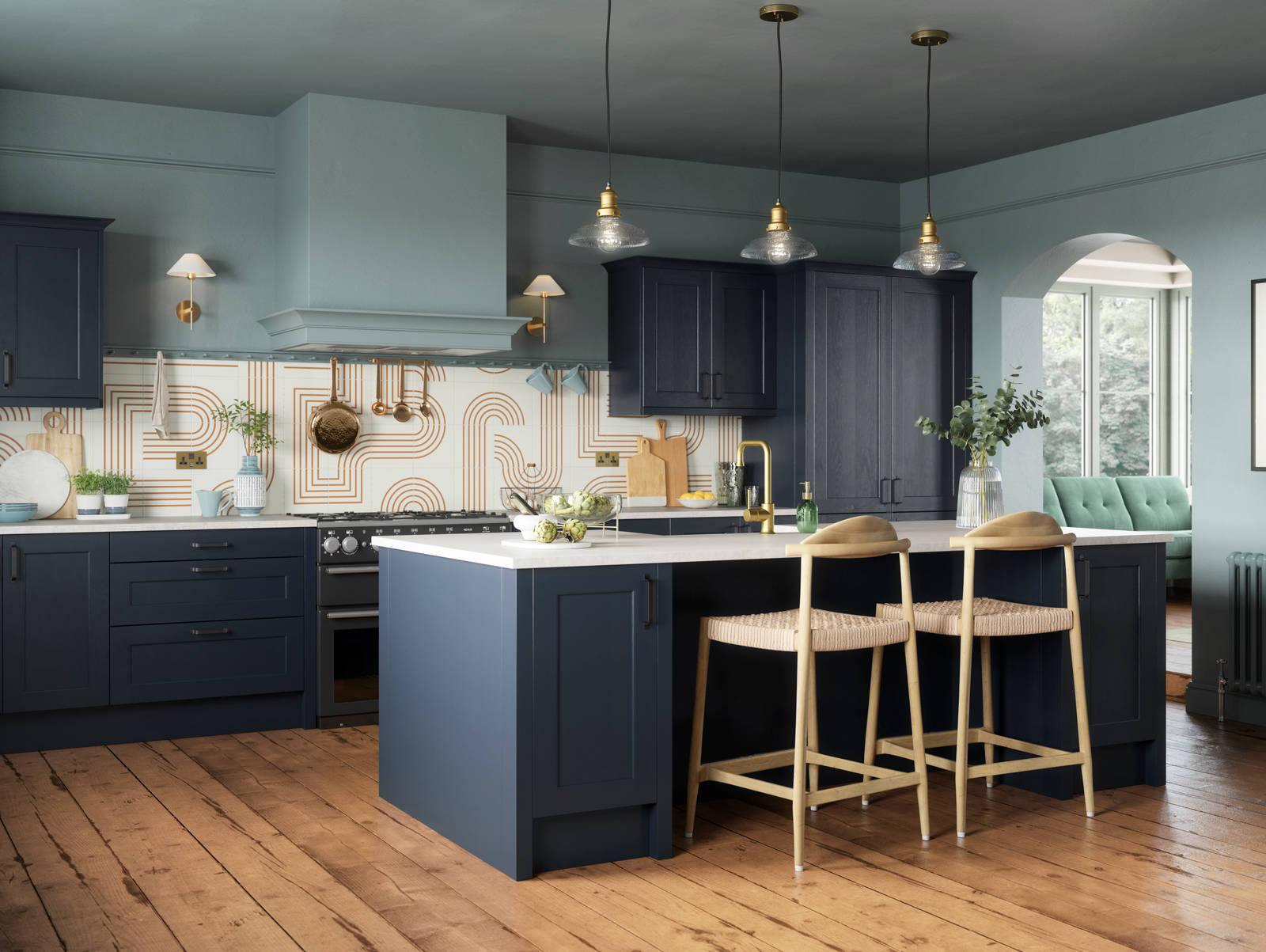 Modern country-style Ludlow kitchen in dark blue shade Midnight, with lighter blue walls, wooden floors and wooden barstools by kitchen island.