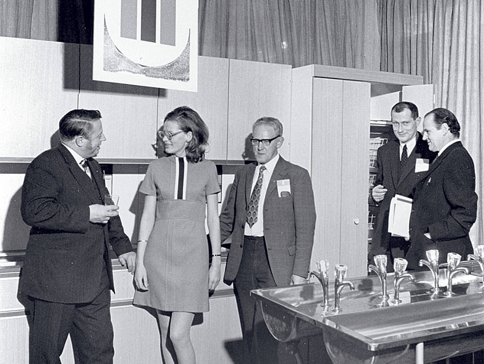 Sort-hvit bild af personer som pratar i showroom