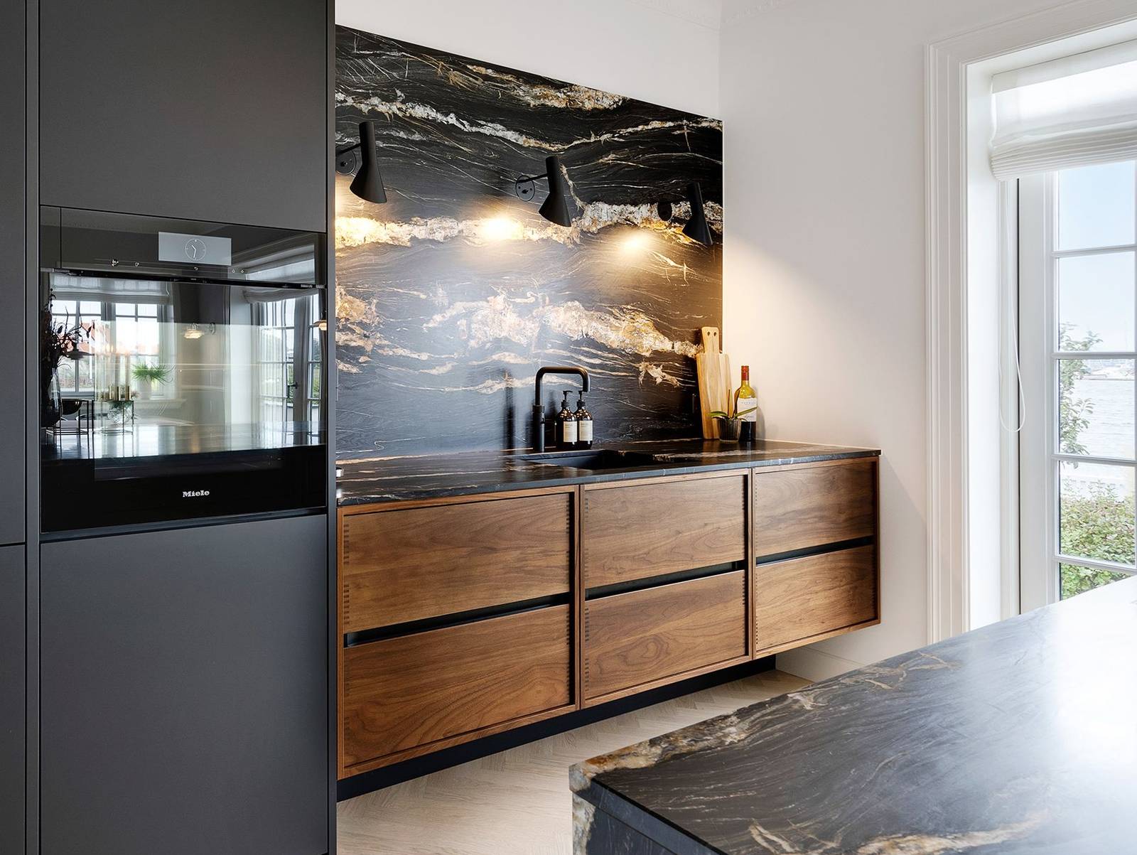 The two tall cabinets contain a fridge, wine fridge, oven and dishwasher