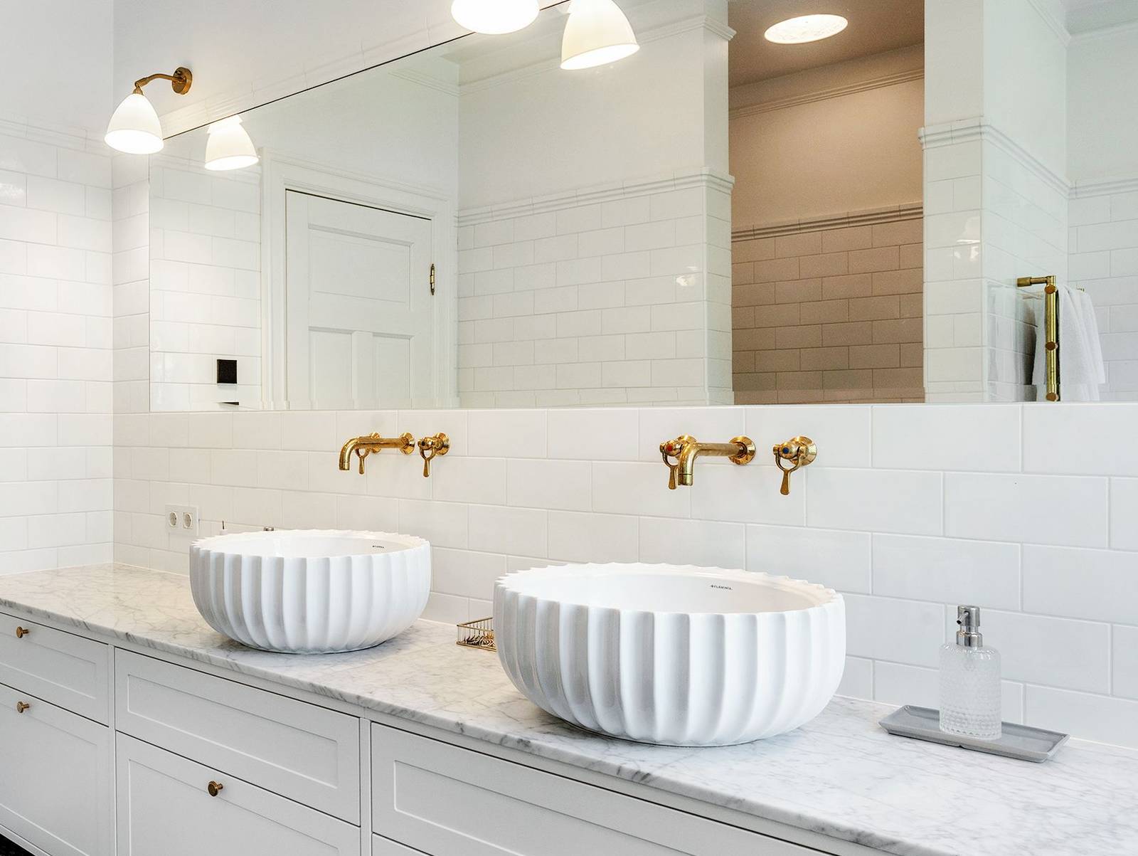 White bathroom in mansion with marble and brass