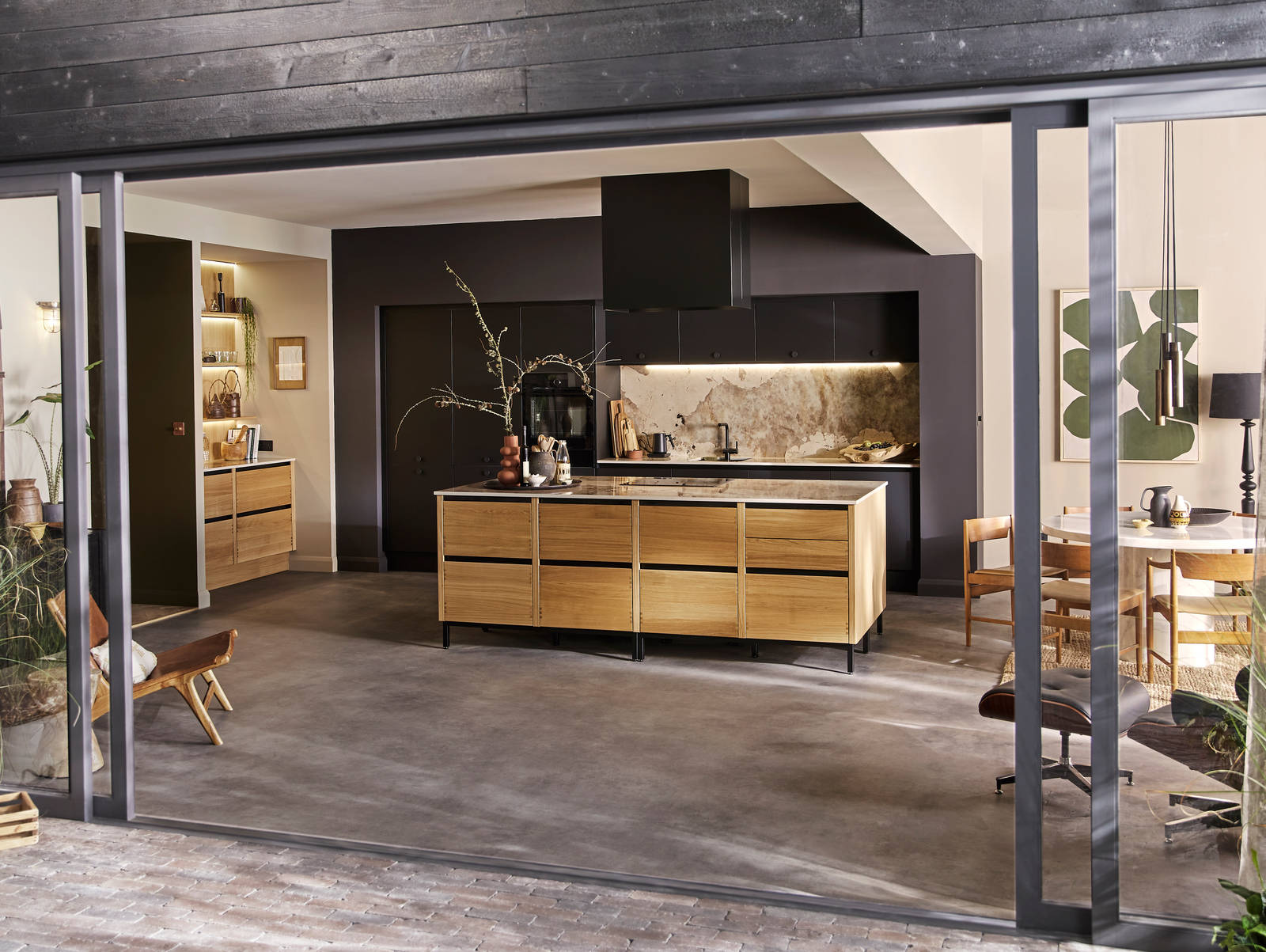 View of the Mindful World kitchen concept through opened glass doors to a patio.