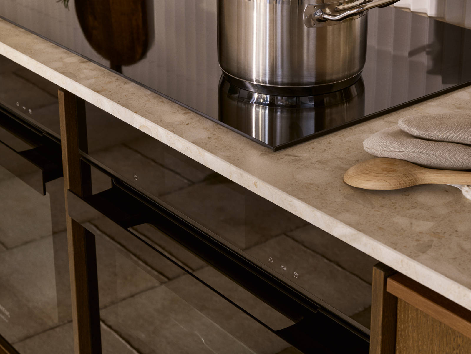 Kastrull på induktionshäll i kök Signatur Ekbacken i ek faner brunbetsad