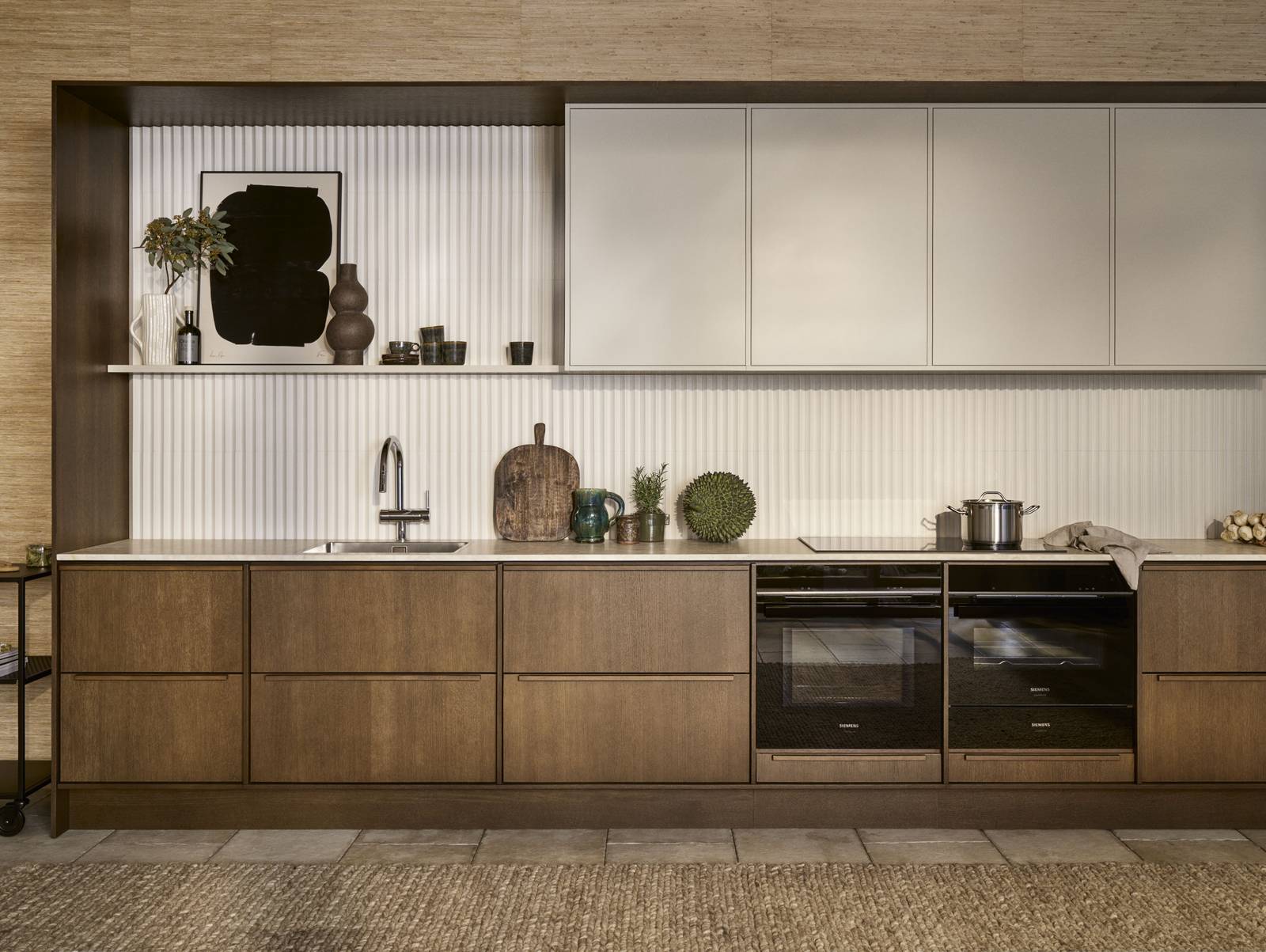 Mørk eg køkkenbænk Forever Oak fra INVITA kombineret med overskaber Athena Sand, hvide fliser, bordplade og massiv ek håndtag, ovn og dampovn fra Siemens