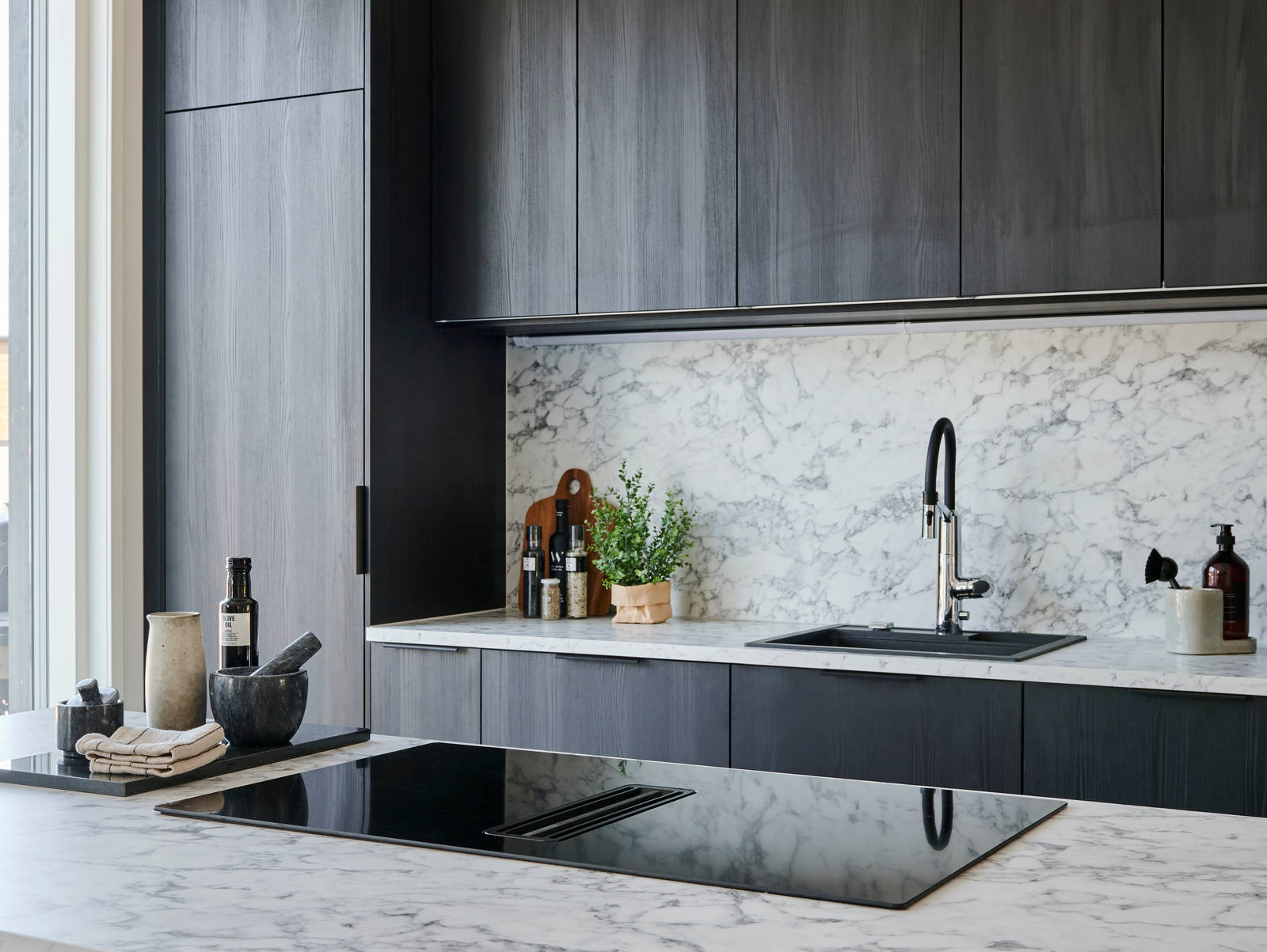 Ovimalli: melamiinia, sävy 149 hiiltynyt puu
Aamiaiskaapin tausta: melamiinia, sävy vaalea puu
Vetimet: MU20 musta lippavedin
Laminaattitaso, sävy 619 vaaleanharmaa marmori
Allas: Upotettava kvartsikomposiittiallas Stala CEG51-57B
Hana: Oras Optima 2739F