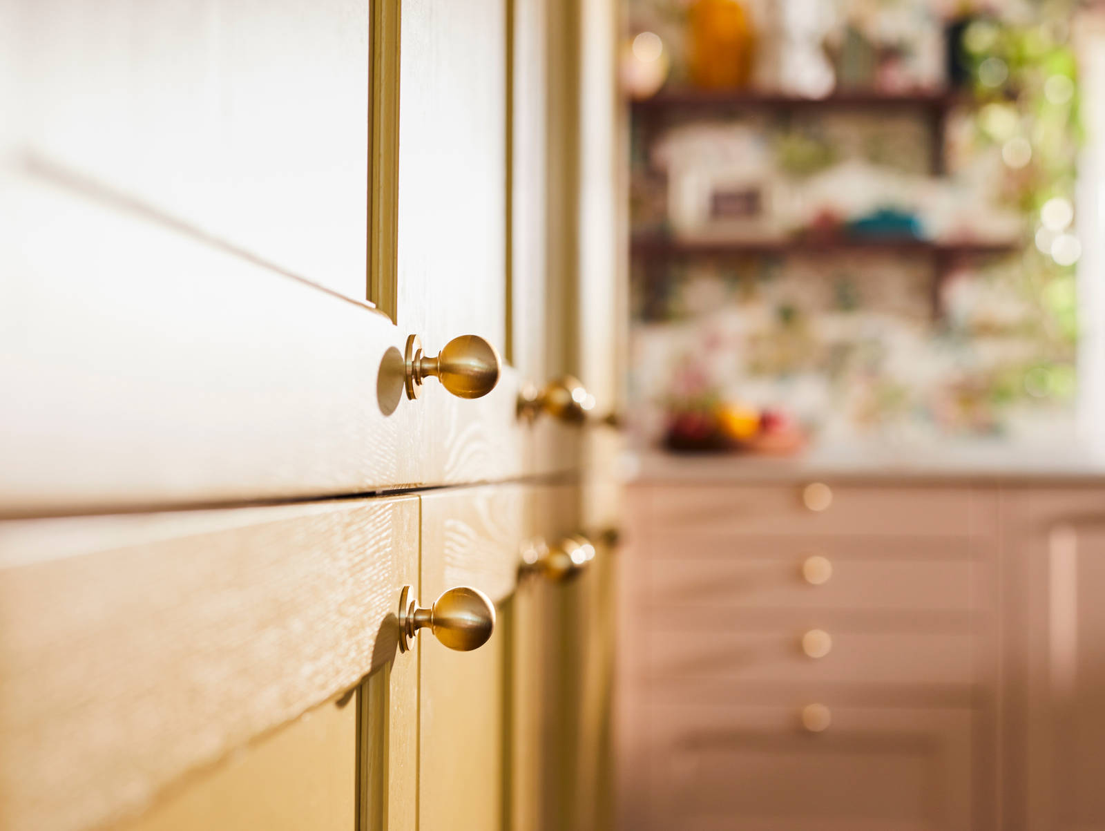 Close-up view of Douglas handles in Brushed Satin brass on Ludlow Harvest cabinets