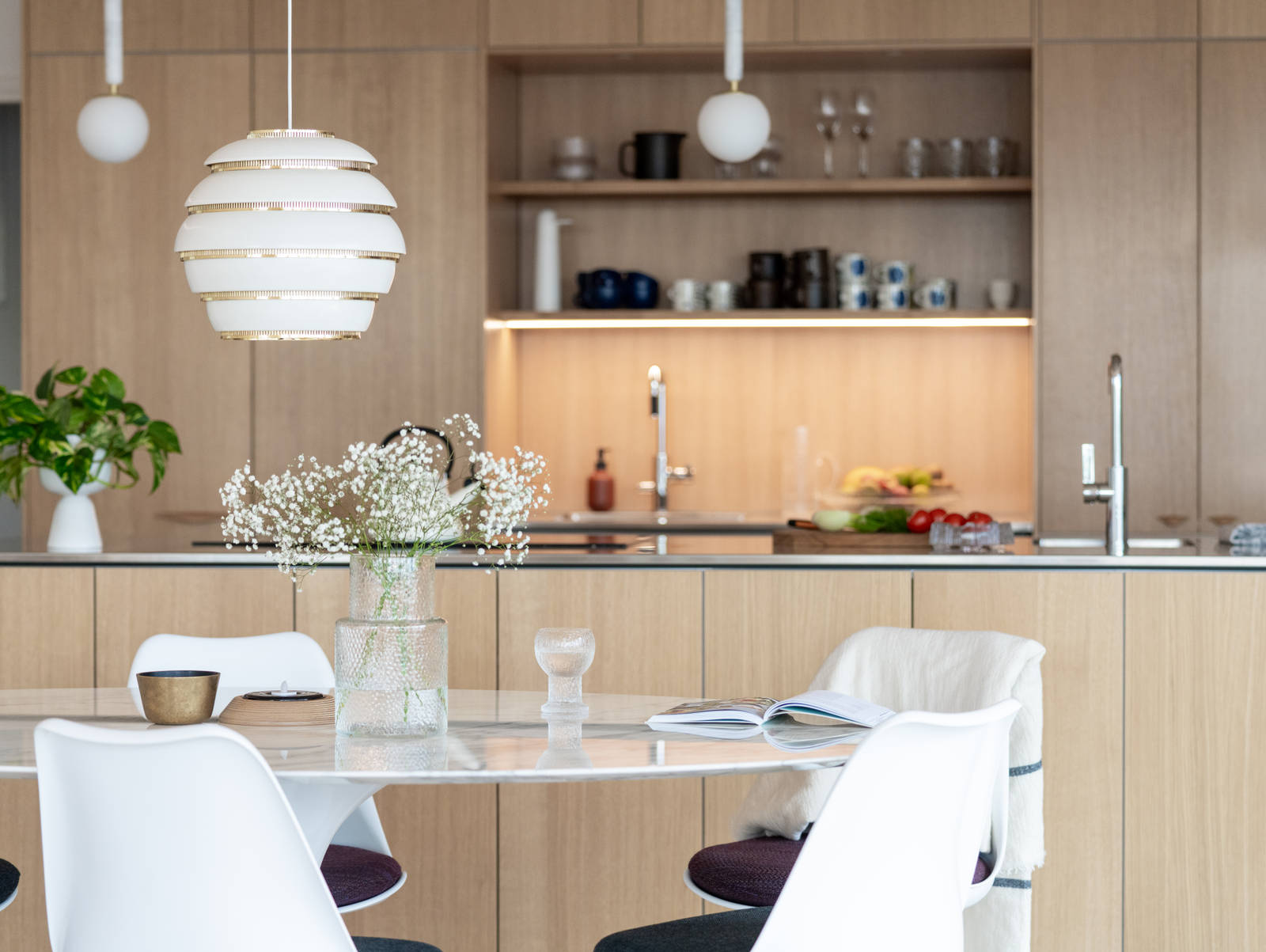 Aitoa luonnontammea Novartilta, yhdistelmä yhteensopivia puisia ja painonappikahvoja, keittiösaareke hanalla, tiskiallas ja ruostumattomasta teräksestä valmistettu työtaso.