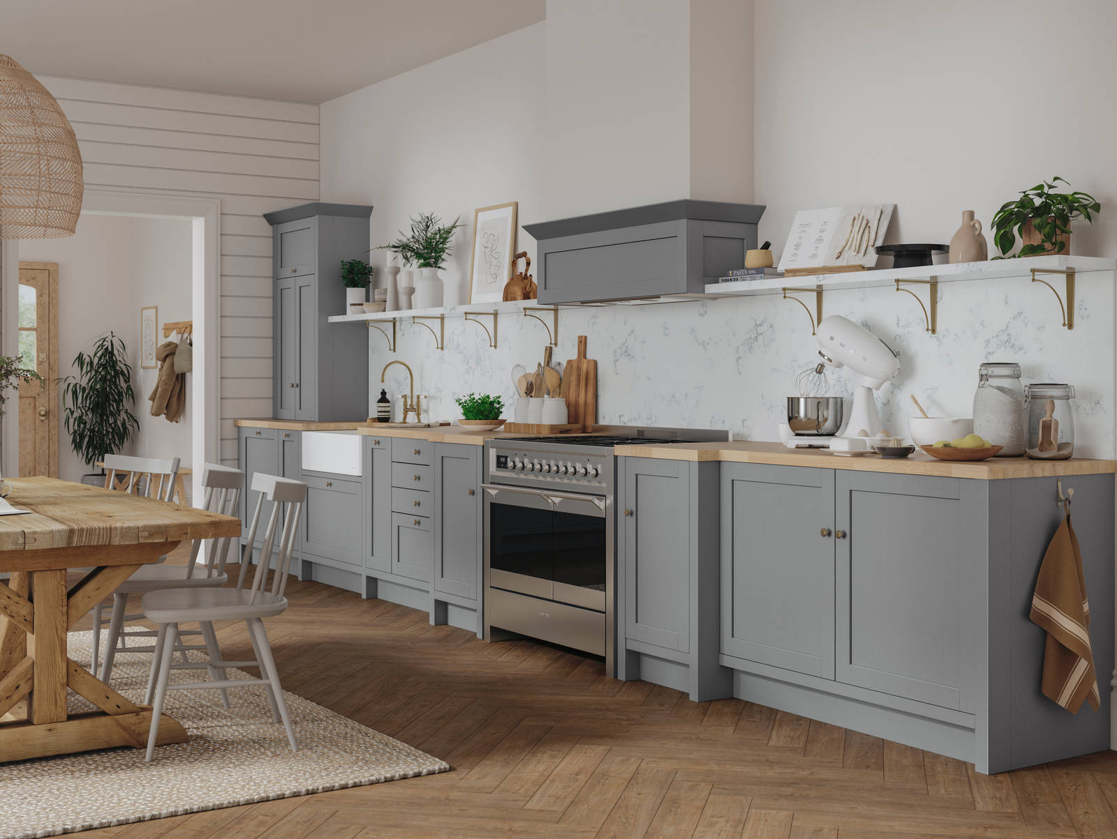 A grey Shaker kitchen seen with a wooden dining table and accessorised with plants.