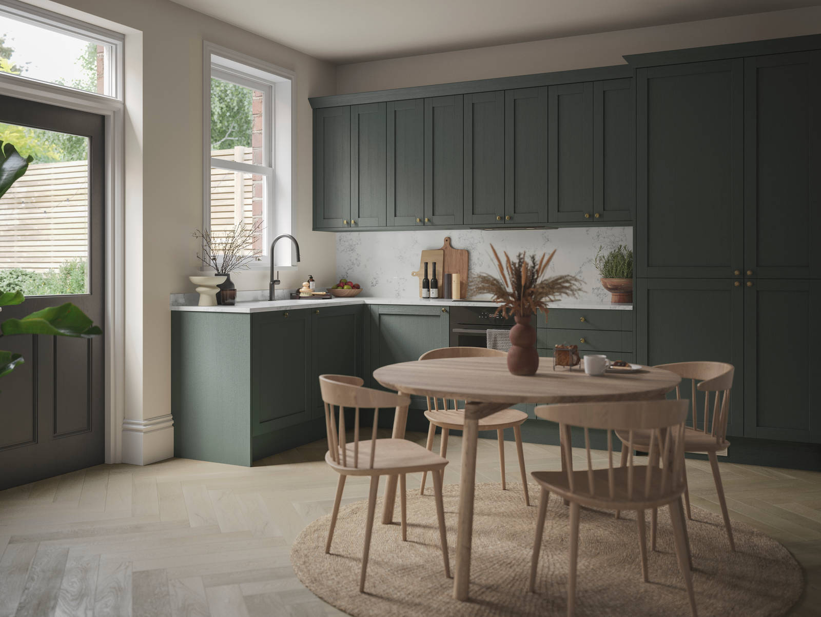 The Ambleside Shaker kitchen in a dark green, seen with a wooden dining table.
