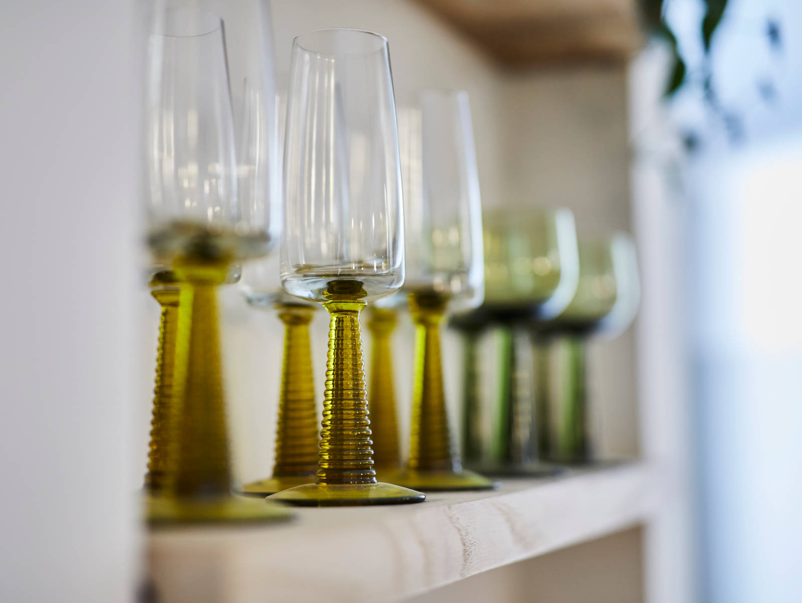 Close-up of wine glasses on an open shelf