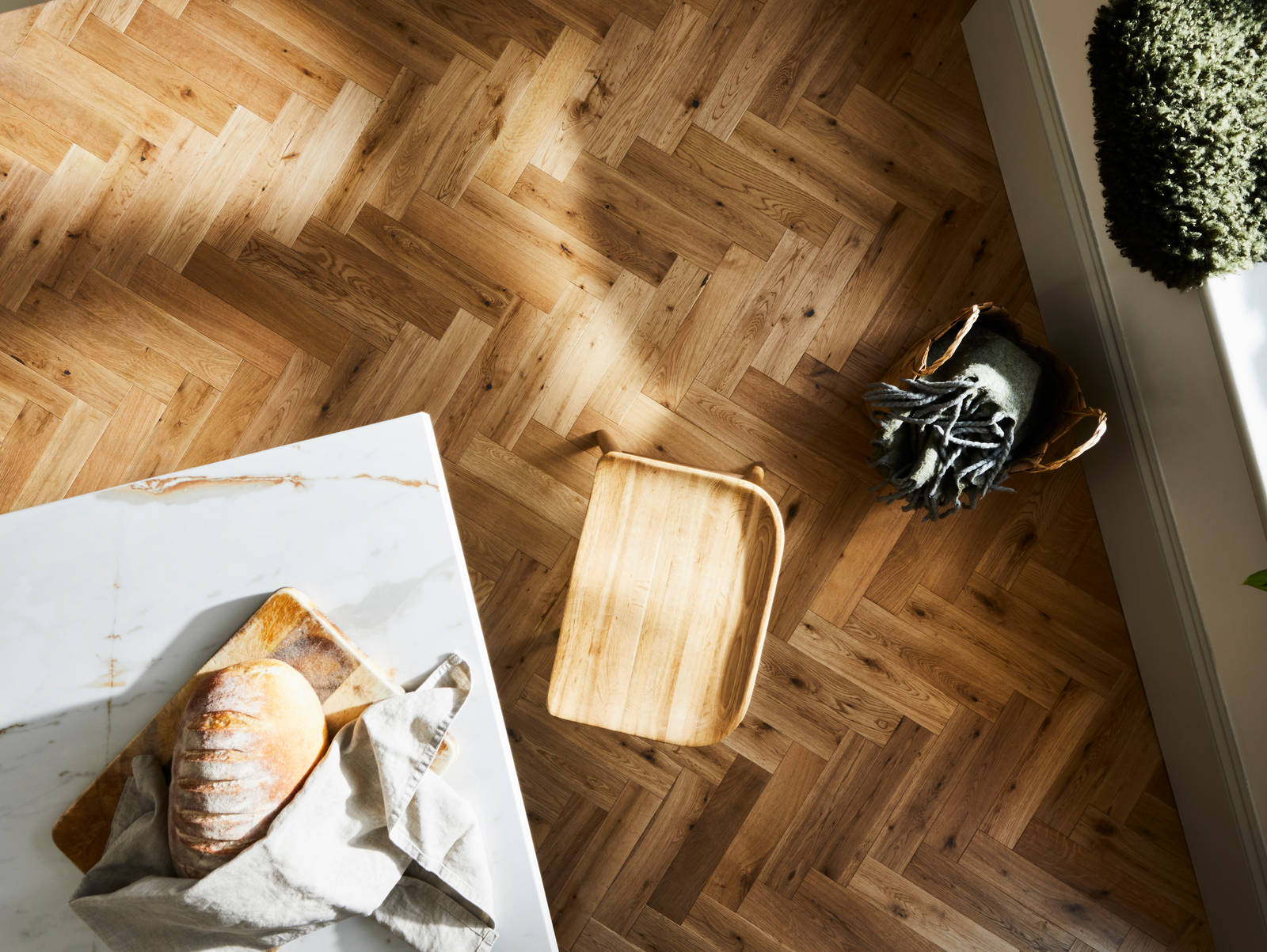 Overhead view of marbled worktop kitchen island corner and the wood floor
