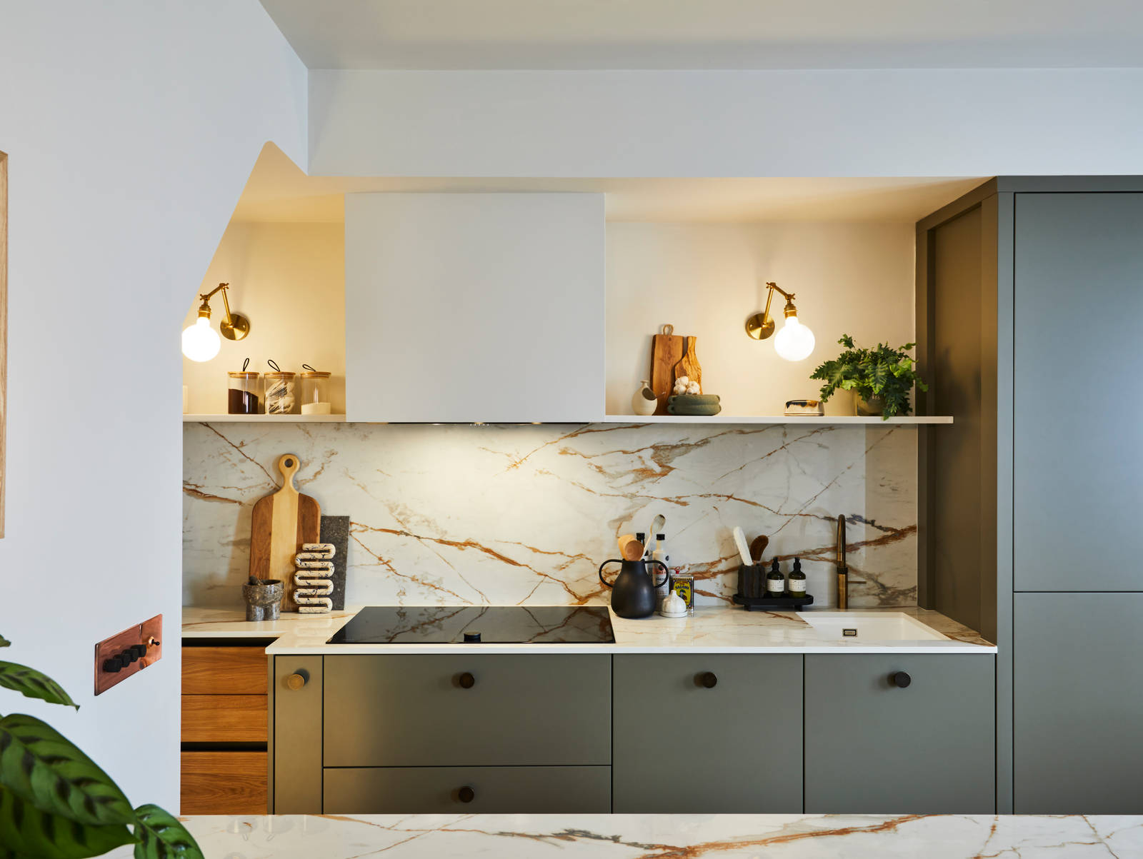 Straight view of modern slab Soho cabinets in the Balmoral colour, paired with a marbled earthy tones Dekton worktop and splashback