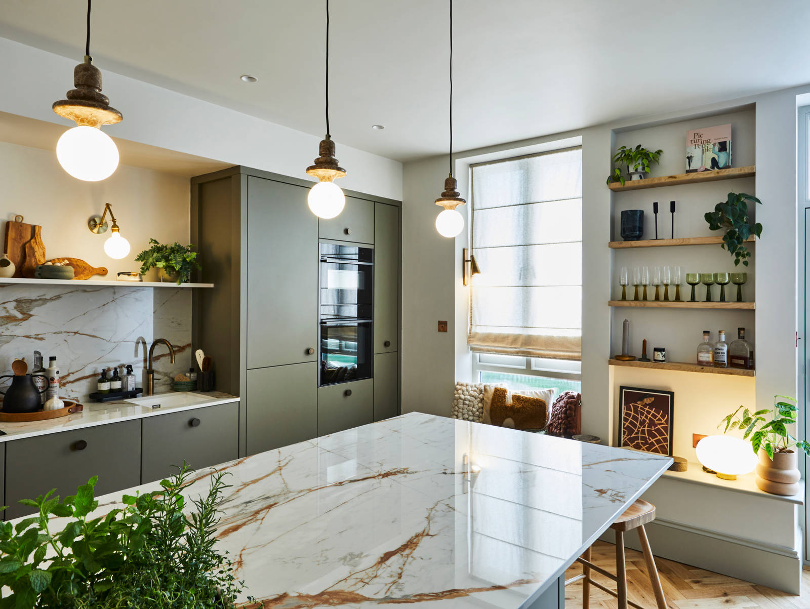 View over kitchen island of modern slab Soho cabinets in the Balmoral colour, a soft beige green tone
