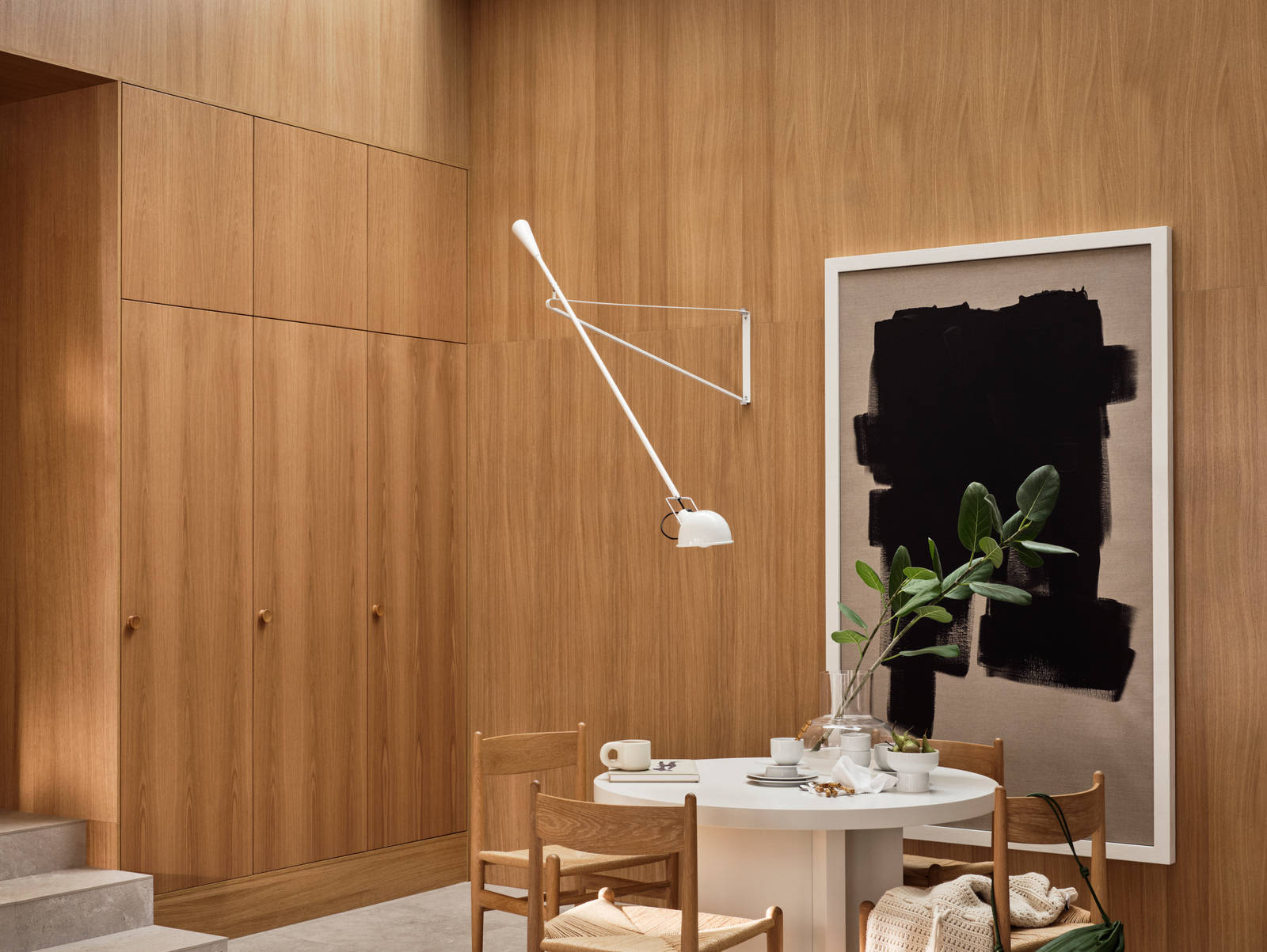 Jubilæumskøkken fra INVITA med elegant træfinér eg, matchende vægpanel og skaber inspireret av 1970'erne, hvid bord med stoler i tre