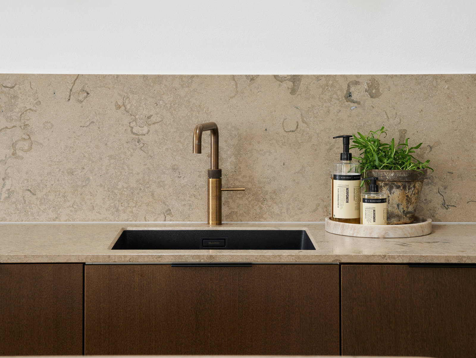 Forever Oak køkken med mørke træ fronter, marmor bordplade og splashback, sort vask og messing armatur