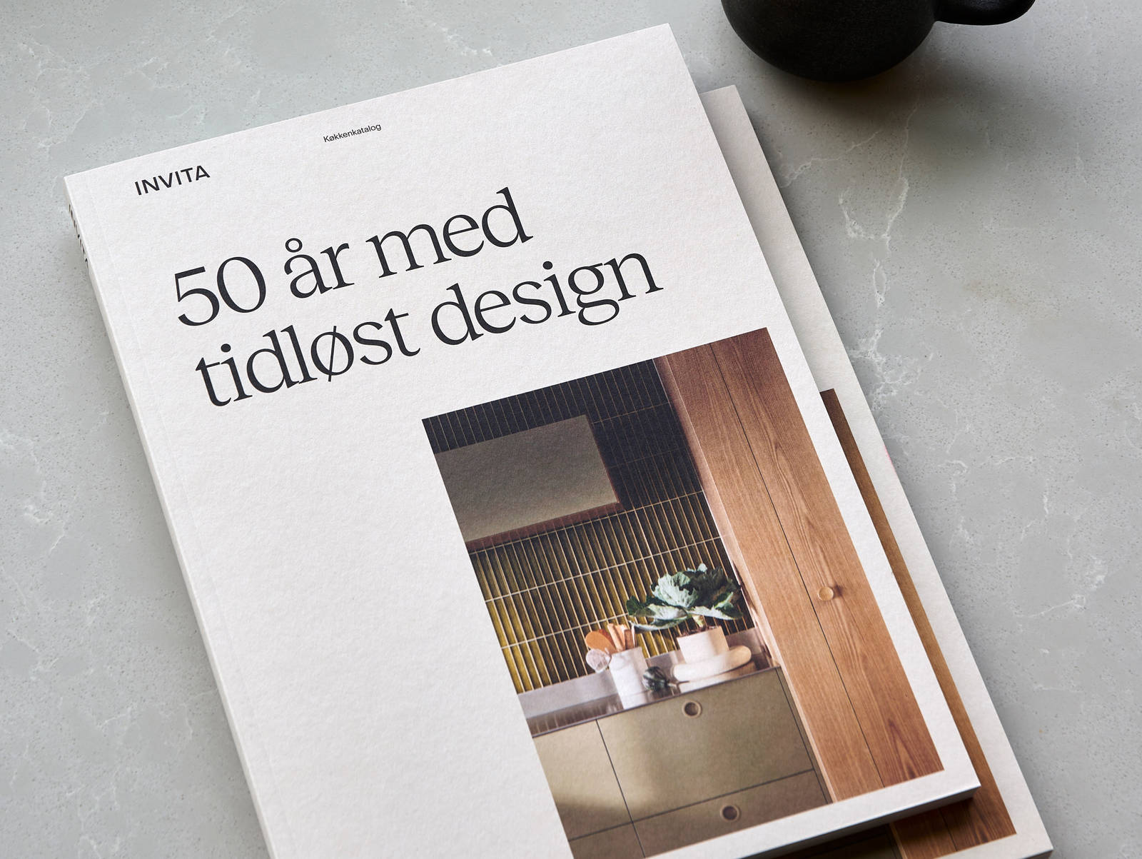 Katalog fra INVITA og kaffekop på bordet