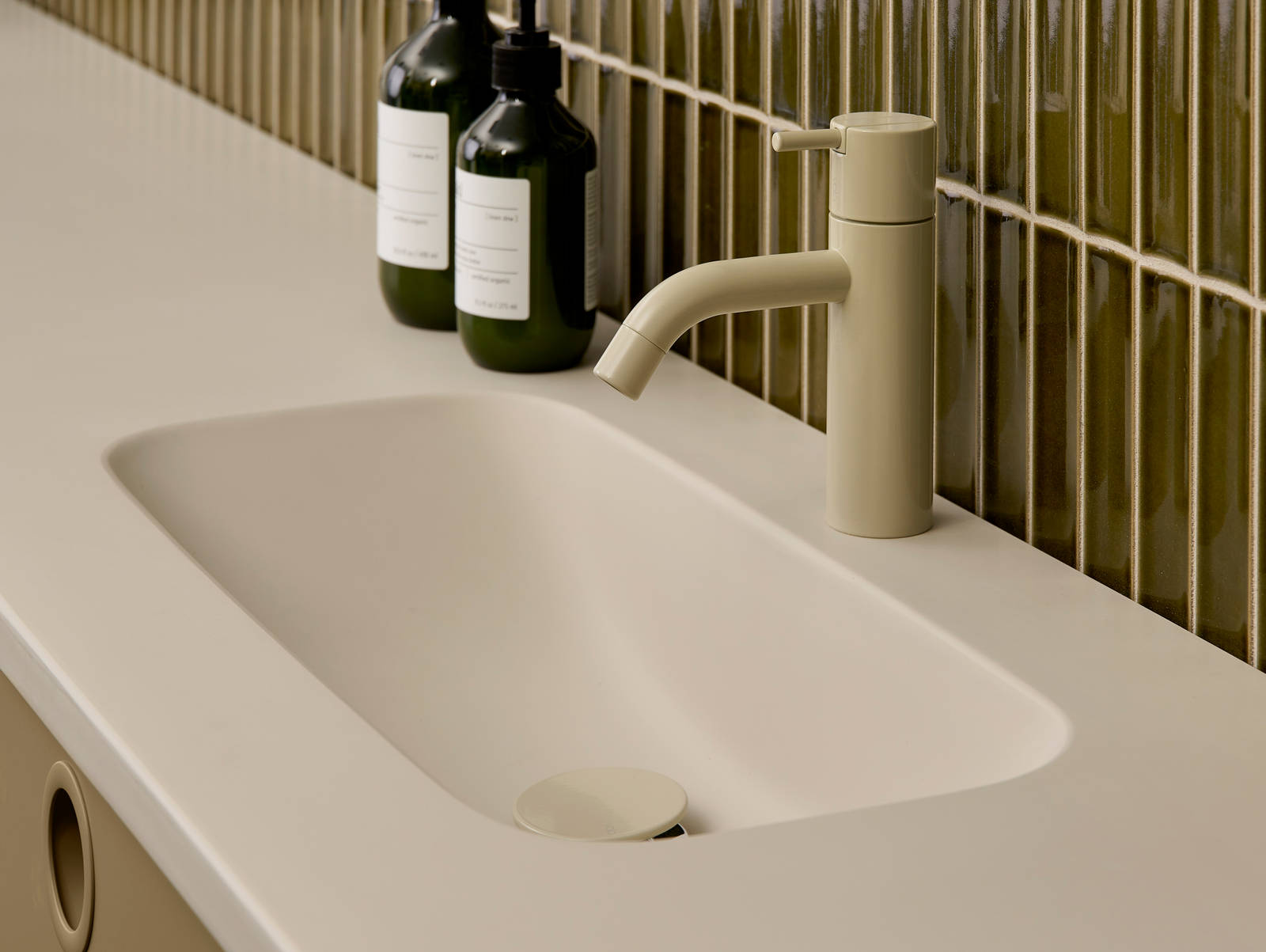 Nærbillede av vask og armatur i Jubilæumsbad fra INVITA med grønne skaber inspireret av 1970'erne, og grønne fliser