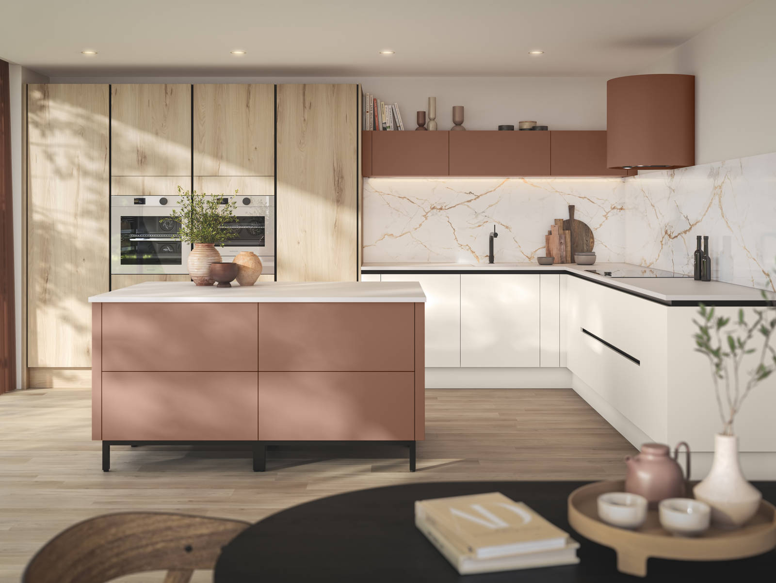 Integra Portobello Bosco as tall cabinets with integrated Samsung Ovens, white handleless Integra Soho cabinetry and a kitchen island in the shade Baked Clay, matching top cabinets and the beautiful fan above hob, all decorated with earth tone ceramics and plants.