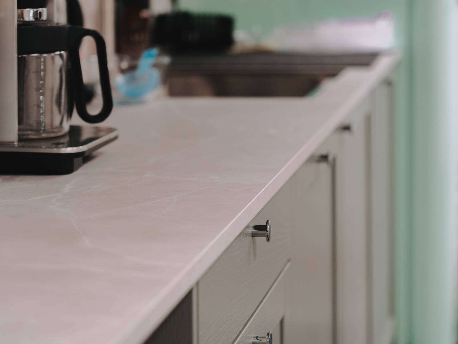 Grovkjøkkenet til kokkene med Vidde korn fra Sigdal, Delaware laminat benkeplate og krom håndtak, Quooker kran og Smeg hvitevarer.