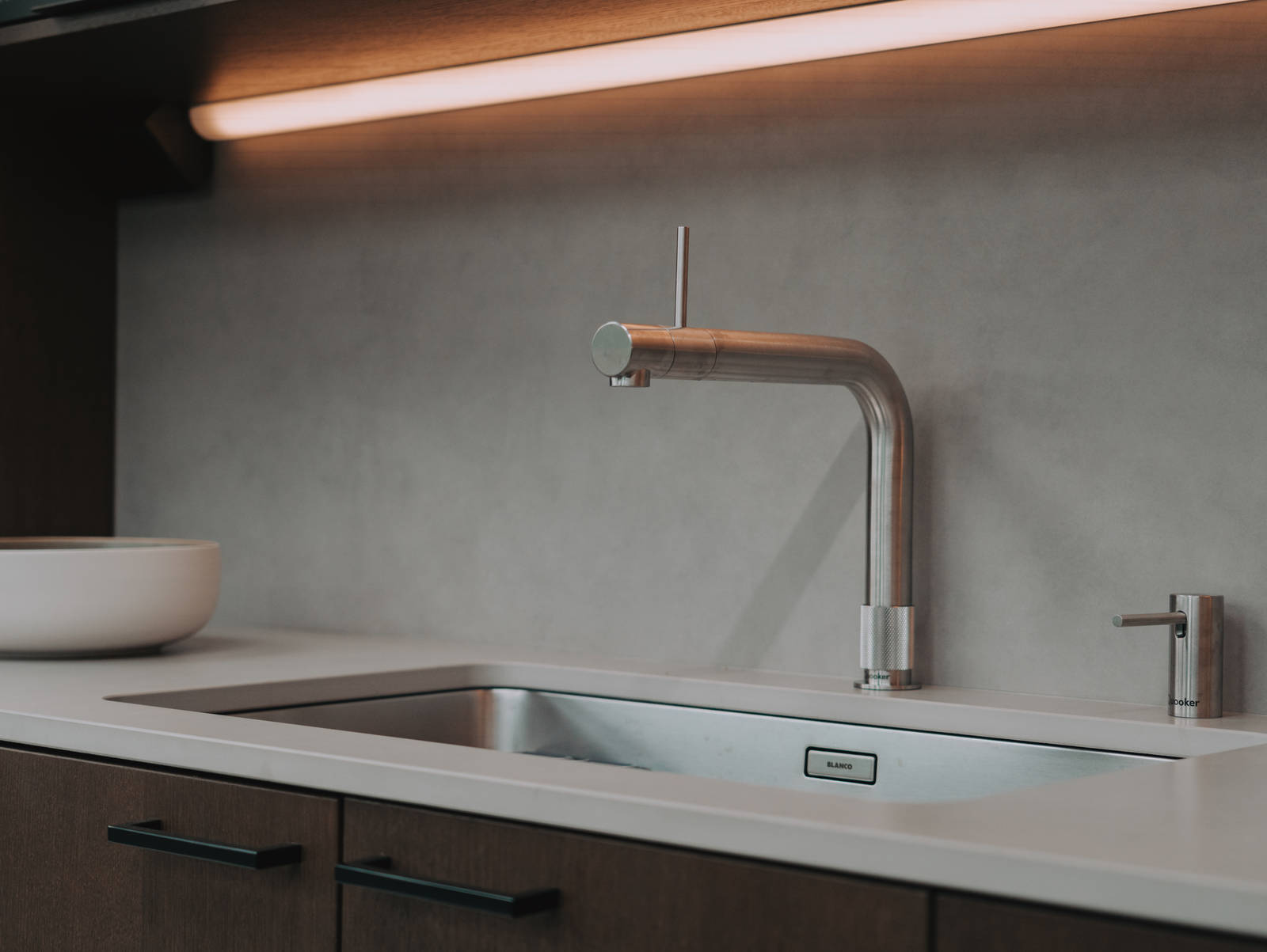 Nærbilde av kran og vask i kjøkken Favn Nøtt i lekker eikefinér fra Sigdal med Kandia Marmor benkeplate i God Morgen Norge studion sin