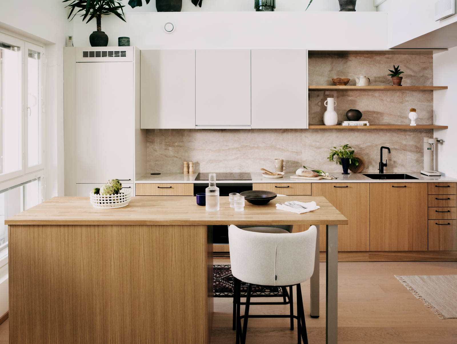 Keittiössä puiset alakaapit, yhteensopivat seinähyllyt ja valkoiset yläkaapit sisäänrakennetulla liesituulettimella