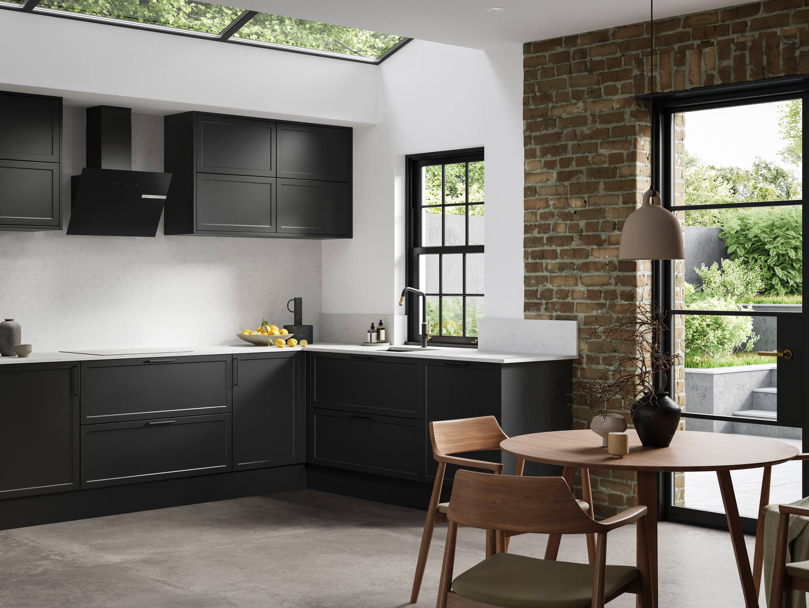 View of modern shaker kitchen Brunswick Sumi Black, with screen extractor over induction hob, black frame skylights with wood dining table and chairs in foreground, combination of white walls and sxposed brick wall.