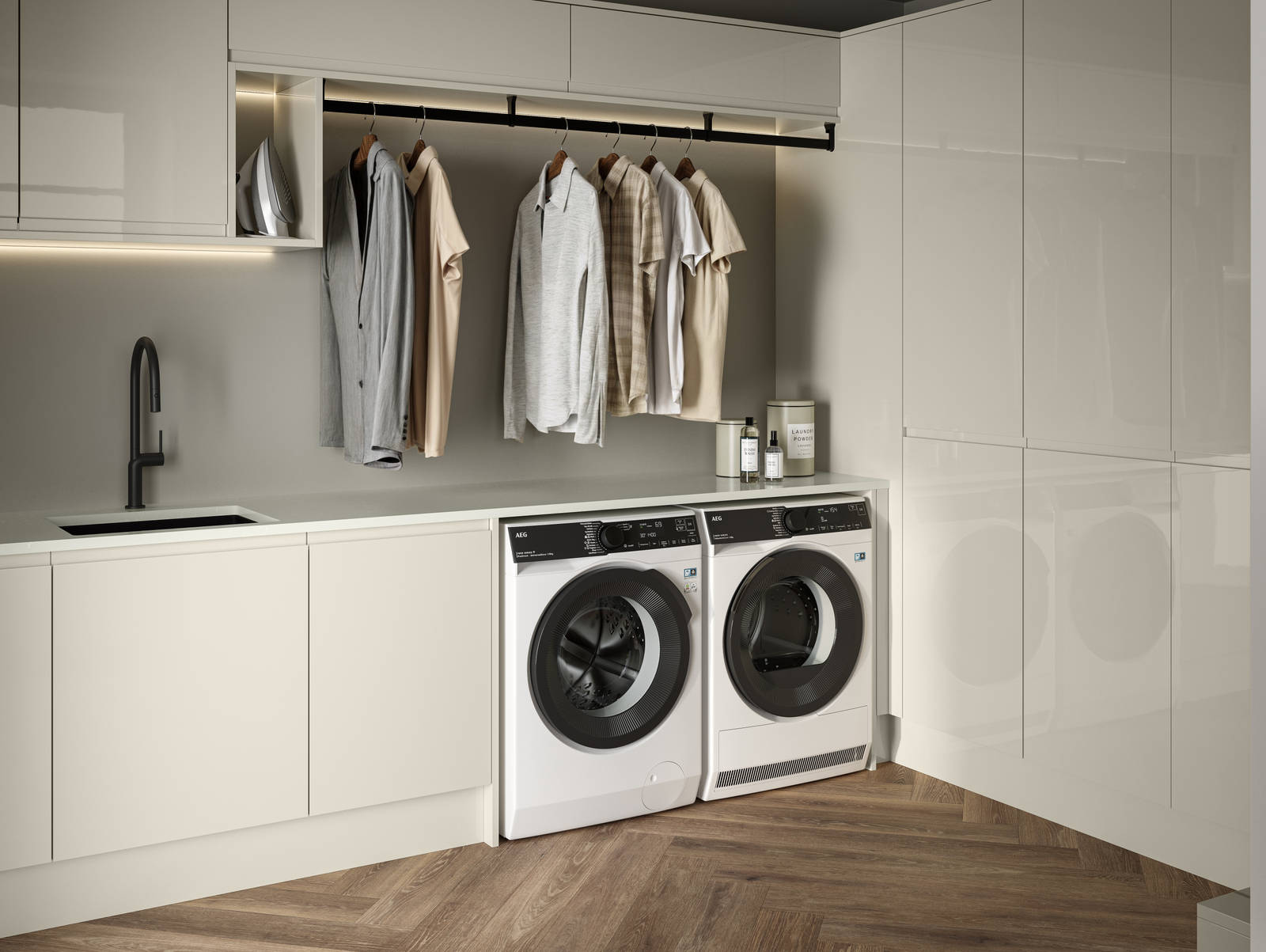 Contemporrary and elegant Luna Gloss Limestone kitchen with integrated washing machine and tumble dryer, tall cabinets, coat hanger under top cabinets and a black sink matched with black tap and Amtico smouldering oak parquet flooring.