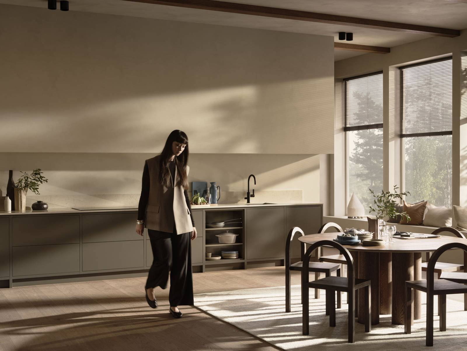 Lämmin minimalismi - Nainen kävelemässä keittiön läpi.
